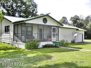Solid well built home being sold below appraised value, this 3 bedroom home is just a short drive from town, it features oak hardwood floors, metal roof,double pane windows,screened front porch, compact kitchen, bonus room off kitchen could be used for formal dining or a family room, laundry room, one car garage, metal storage shed,and utility shed, partially fenced, all on paved road and ready to move into. Call agent today to see this home.