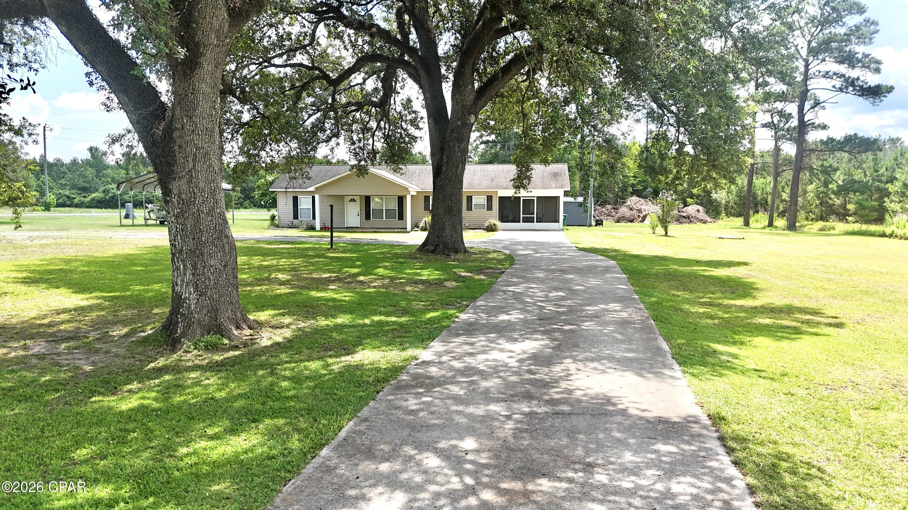Beautiful country home located in Grand Ridge, FL on 2 high and dry acres, shaded by stunning mature oak trees that give this property incredible curb appeal.

This 3 bedroom, 2 bathroom home offers just under 1,300 sq. ft. of heated and cooled living space with over 1,800 sq. ft. under roof. Inside you'll find granite countertops, solid wood cabinetry, and a functional layout designed for comfortable everyday living.

One of the standout features is the huge screened porch on the side of the home, perfect for relaxing, entertaining, or enjoying the peaceful country setting. The porch also includes an attached storage room, providing plenty of extra space for tools, equipment, or seasonal items.

Additional features include:
• 3 Bedrooms | 2 Bathrooms
• Granite countertops
• Solid wood cabinets
• Large screened porch with attached storage room
• 2 acres of flat, usable land
• Corner lot with frontage on Hwy 69 and Butler Rd (both paved roads)
• Beautiful mature oak trees

If you're looking for a well-maintained home with space to spread out and enjoy country living, this one is worth a look.