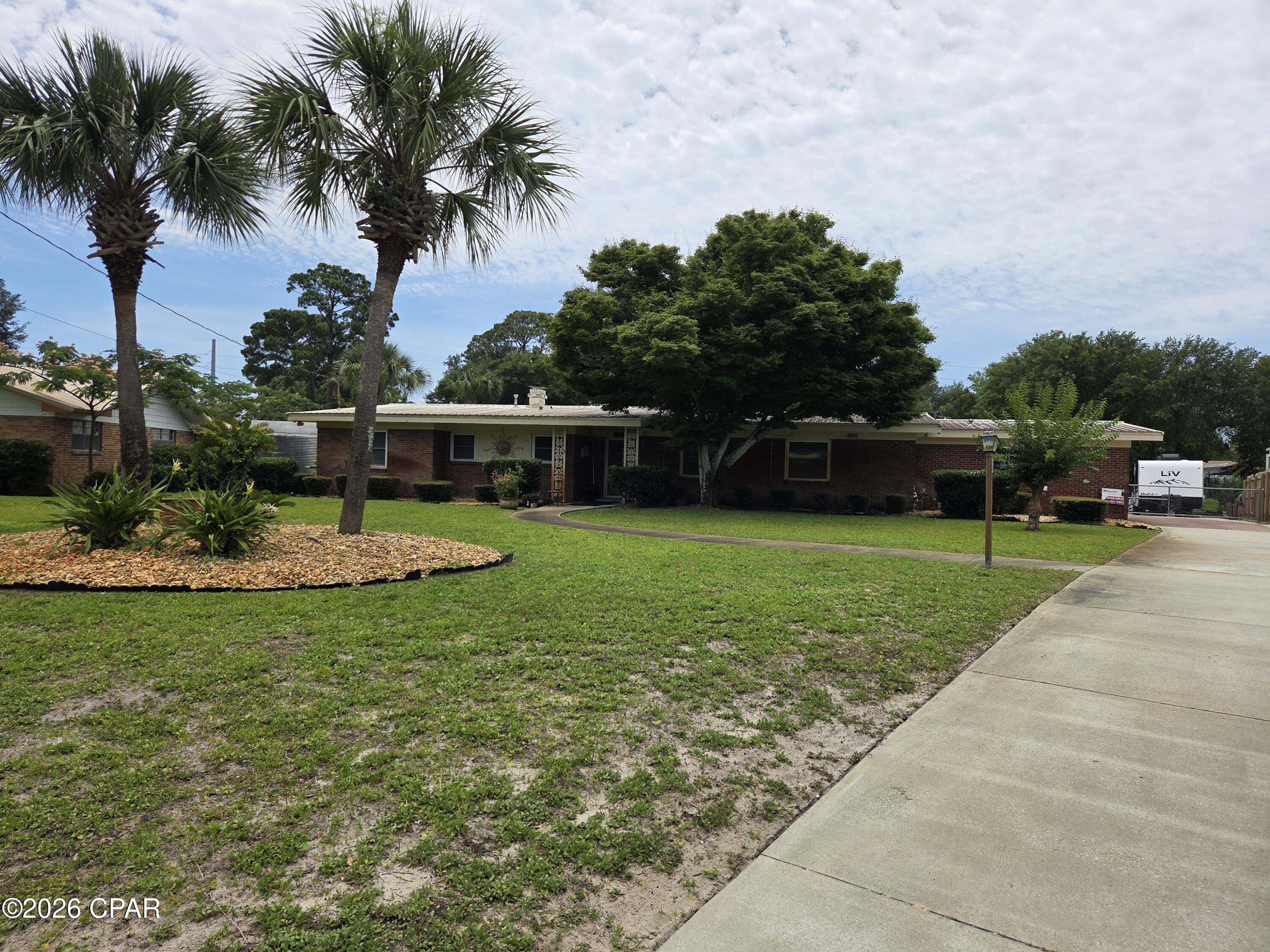 Rare opportunity to own a waterfront home in the historic Woodlawn community, one of Panama City Beach's earliest planned neighborhoods. This charming 1958 canal-front residence offers the perfect blend of Old Florida character, boating convenience, and an unbeatable location with no HOA.

Situated on a wide canal with approximately 191 feet of seawall frontage, this property is a boater's dream. Enjoy direct access to St. Andrews Bay and the Gulf of Mexico from a canal averaging 5-6 feet deep at center and approximately 80 feet wide, providing excellent maneuverability for larger vessels. The private dock is equipped with an I-beam boat lift capable of accommodating boats up to 30 feet in length, making it easy to get on the water at a moment's notice.

Inside, the home features 3 bedrooms, 2 full baths, and a convenient half bath near the garage. The Florida room expands the living space and creates an ideal indoor-outdoor transition area for relaxing or entertaining. Additional highlights include a built-in mini bar, a covered outdoor patio, and a built-in BBQ grill with a functioning flue system, creating the perfect setting for waterfront gatherings.

The waterfront lifestyle is what truly sets this property apart. Spend your days fishing from your dock, cruising to Shell Island, exploring St. Andrews Bay, or enjoying some of the area's popular boat-accessible restaurants. Whether it's a morning fishing trip, an afternoon at Shell Island, or a sunset cruise with family and friends, this home offers endless opportunities to enjoy life on the water.

Conveniently located just minutes from the shops, restaurants, and entertainment of Historic St. Andrews and Downtown Panama City, and only a short drive to Pier Park, you'll enjoy the best of both worlds--peaceful waterfront living with easy access to some of the area's most popular destinations.

Waterfront homes with this combination of character, boating amenities, expansive seawall frontage, and prime Panama City Beach location rarely come available. Don't miss your chance to own a piece of coastal Florida history and start living the waterfront lifestyle you've always imagined.