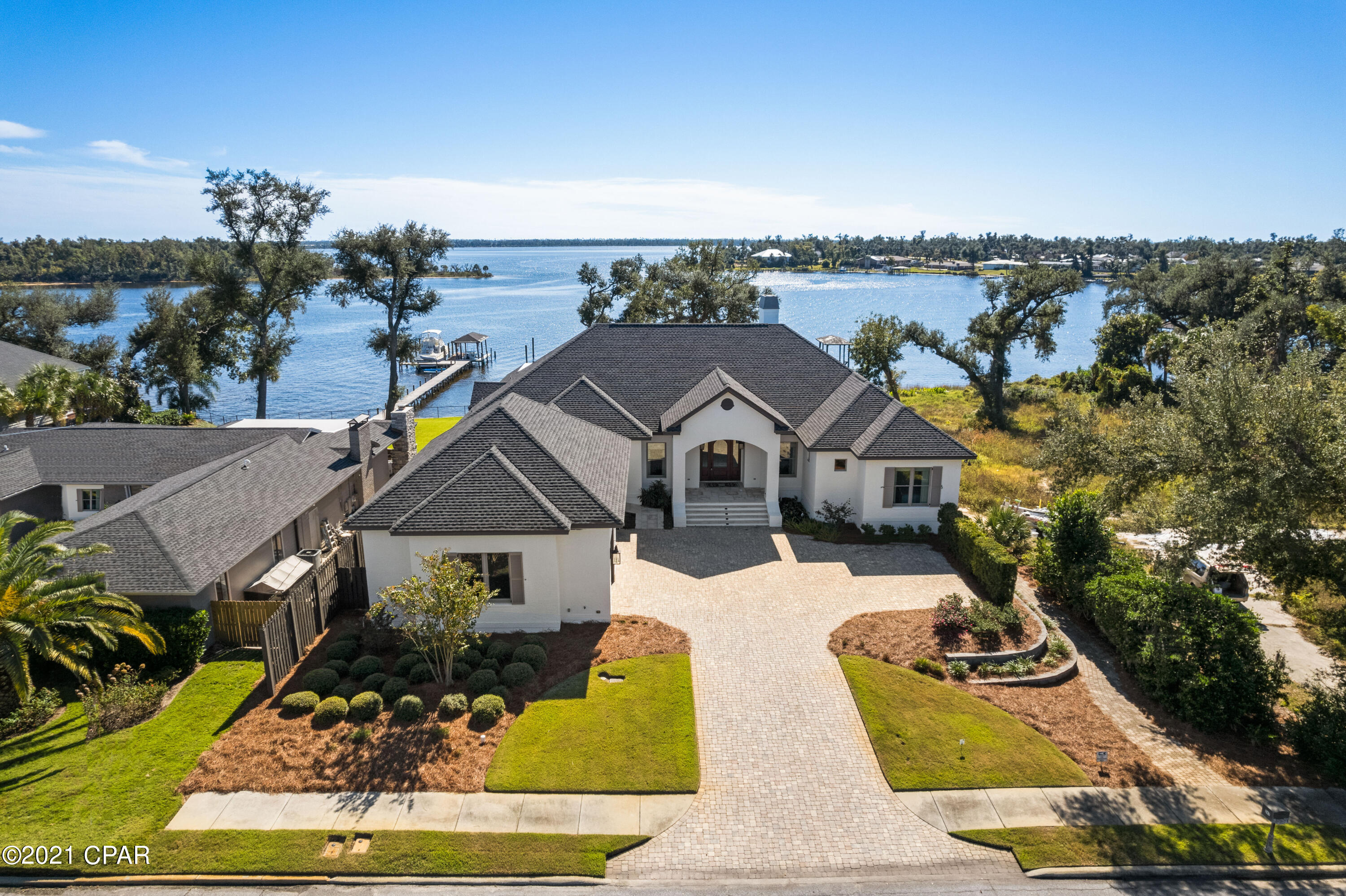 Currently under contract, seller accepting back up offers. This modern, transitional waterfront masterpiece 6,700 SF residence takes full advantage of its bayfront location, blurring the lines between indoors and out while allowing for the most pleasurable resort-like lifestyle. The breezy outdoor spaces and light-filled, view-focused interiors offer relaxed and refined modern living. With over 100 feet of water frontage on St. Andrews Bay, this home boasts a private boat lift, boat house and dock leading from the water to the estate's lavish amenities which include a pool, hot tub, screened-in outdoor kitchen, and accordion doors that lead to an exceptional family room and wet bar. A generous green space offers additional room for family games, entertaining and capturing the best views that waterfront living can afford, with no HOA. The outdoor space includes a full bath and climate-controlled bonus room, both adjacent to the pool. An expansive pool deck for large gatherings is perfect! 

Beyond the mahogany French doors, an open floor plan reveals pure Bay views, tongue and groove ceilings and expansive light-filled living spaces. Rich details throughout including stunning hardwood floors, vaulted ceilings, custom millwork covering the television and a gas fireplace. Meticulously designed window seats and an abundance of windows showing stunning views of the Bay, pool, and dock. The chef-style kitchen has custom cabinetry with a suite of professional grade appliances and a butler's pantry with additional sub-zero refrigerator, dishwasher and more that was designed to be open or closed to your liking. Among the mix of formal and casual spaces, the family room is adjacent to the kitchen and dining room, but all designed to ensure the Bay views are preserved. The main level Master bedroom includes oversized, customized walk-in closets and spa-like en suite, featuring a walk-in shower, soaking tub, dual vanities, and separate water closet room. Four additional bedrooms and three additional bathrooms along with a large mudroom and laundry complete the main level. The lower level of the home offers the greatest entertaining space you've ever seen. This open space includes high ceilings, wet bar complete with a thick honed granite, wine fridge, mini fridge, icemaker and dishwasher and the ability to capture the indoor-outdoor living desired. This level also offers a large bonus room with custom built-in tree houses for the kids, an abundance of storage closets and a private guest room with en suite. A fitness room and safe room/vault also complete the lower level of this home. This waterfront estate offers a whole-home generator ensuring the comfort of its owners and guests as well as a customizable security system, sound system, and lighting system. Notable features of the home include: three-car garage with epoxy flooring and dumbwaiter for storage, hardwood flooring and travertine, custom drapery, custom crown molding, designer lighting and A/C in the attic for maximum climate control and lush landscaping.

Poised within proximity to the famed Shell Island and only 7 miles to the emerald waters of the Gulf of Mexico pass, you'll see why the Cove is truly a boater's paradise. This home offers deep water and perfect for your center-console or sportfishing boat. Adjacent to the home is the neighborhood park where friends and neighbors gather as it is the heart of the community. Located just 2 miles from flourishing Downtown Panama City, you're within a short golf cart ride away from enjoying local brews, live music daily, boutique shopping, a farmers market and more. Along with the world's most beautiful beaches just minutes away, world-class dining on the 30A corridor and welcoming Southern hospitality, you'll be ready to call this your home immediately. *Buyer to verify all measurements, if important.*
