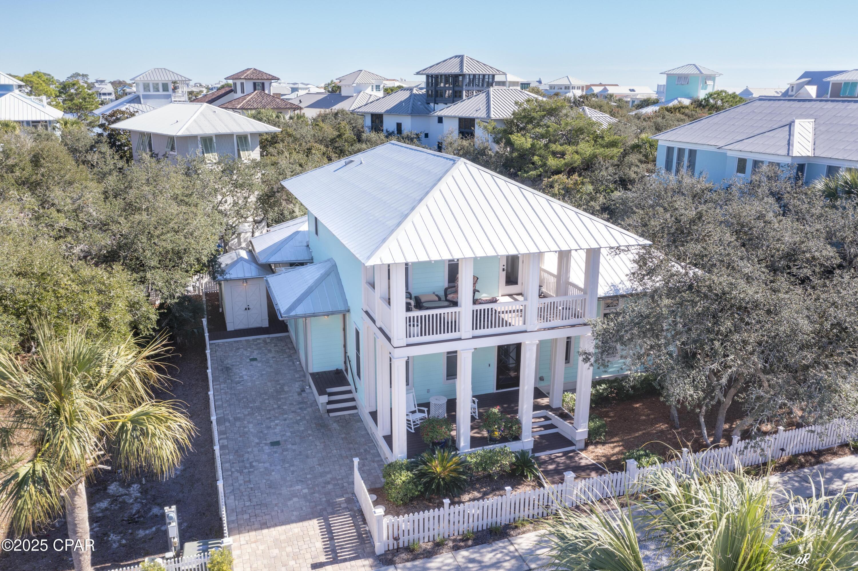 This southern cottage-style beach house, masterfully designed by renowned AIA architect Gary Justiss, is nestled in the serene, private gated community of Carillon Beach. Offering a blend of exclusive privacy and contemporary elegance, this home offers an unmatched living experience near the sea.

The house boasts three nicely appointed bedrooms and four baths, providing ample space for family and guests alike. The master suite, conveniently located on the first floor, features elegant design and comfort, making it a perfect retreat after a day spent by the ocean. The living spaces are graced with tall ceilings that enhance the airy and open feel.

Living spaces extend seamlessly outdoors to the spacious porches, offering a view of the surrounding landscapes and the perfect setting for relaxation or entertaining. The outdoor area further enhances the leisurely beach lifestyle with a convenient outdoor shower, ideal for rinsing off after a beach day, and a bike shed to store beach gear.

Adding to the function and charm of the property, an outbuilding is currently utilized as a combination mancave and greenhouse. This additional structure offers potential for various uses, adapting to the homeowner's lifestyle needs.

The ample backyard, set against a backdrop of lush greenery and coastal breezes, features raised bed planters for gardening enthusiasts. This space is also suitable for accommodating a pool, offering potential for an idyllic outdoor oasis tailored to leisure and entertainment.

Each detail in this home speaks of thoughtful design and high-quality craftsmanship. This beach house embodies a lifestyle perfect for those seeking a permanent residence, a holiday home by the sea, or an investment property.