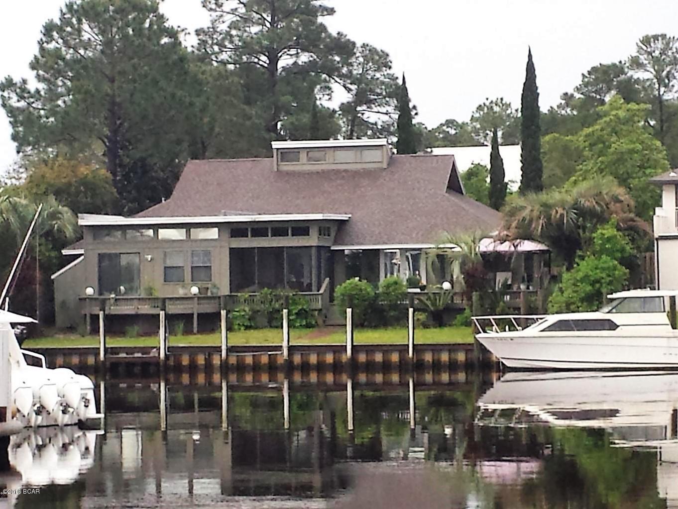 Absolutely fabulous is the only way to describe this Bay Point Canal Front Home!! Updated throughout, custom tile, granite, Viking gas range, double oven, stainless appliances. Built-in 1080p HD projector stays with house, 10' screen in living room. Key West style tongue and grove vaulted ceiling in living room. Gas fireplace. Huge master bedroom with massive walk in closet. Oversized master bath with jetted tub, shower and separate toilet area. Separate formal dining area. Bar area with built-in ice maker. Large wrap around deck with screened lanai and sauna. 1500lb capacity boat lift. Motor to the pass in 10 minutes.... Two car garage with work area. New custom master shower with multiple spray nozzles. Custom tile work in secondary dining area. New doors, exterior stain, garage door opener and landscaping. Close to owner's entrance gate (Thomas Dr.) for easy entry and exit to/from the community. Gated, 24 hour security. Bay Point is the premier canal/golf course community in the PCB area. On-site Marina, Jack Nicolas Golf Course, Serenity Resort and Spa, Post Office and several restaurants to choose from, many within walking distance and/or within the confines of the community.  Make your appointment today!!