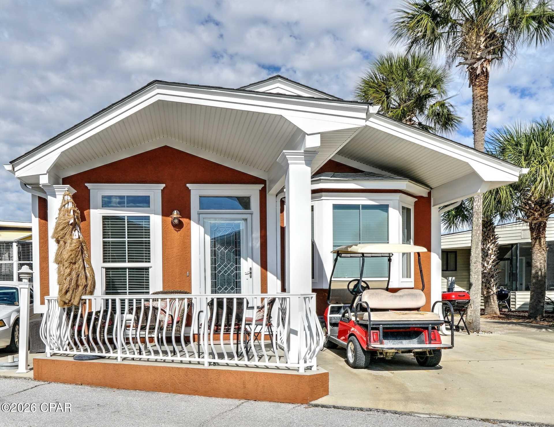 Welcome to this beautifully maintained 3-bedroom, 2-bath beach home located in the highly desirable gated community of Venture Out in Panama City Beach. Offered fully furnished and including a golf cart, this turnkey property is ready for immediate enjoyment as a primary residence, second home, or income-producing vacation rental.

The open-concept floor plan features soaring vaulted ceilings with attractive wood accents, creating a bright and spacious living area. The well-appointed kitchen offers custom cabinetry, solid surface countertops, stainless steel appliances, ample storage, and bar seating, making it ideal for entertaining family and guests.

The spacious primary suite provides a relaxing retreat, while two additional bedrooms offer comfortable accommodations for visitors. Coastal finishes and tasteful furnishings throughout the home create a warm and inviting atmosphere.

Outside, enjoy the covered front porch, perfect for morning coffee or evening relaxation. The oversized parking area provides ample room for vehicles, and the included golf cart makes it easy to access all of the resort's amenities.

Venture Out is a premier golf-cart-friendly waterfront community featuring approximately 300 feet of private Gulf frontage and 1,000 feet of Grand Lagoon frontage. Amenities include two swimming pools, a private beach, marina, boat ramp, fishing pier, tennis courts, pickleball courts, basketball court, playground, shuffleboard, and 24-hour gated security.

Conveniently located near restaurants, shopping, marinas, and the attractions of Panama City Beach, this exceptional property offers the perfect combination of coastal living and investment potential. Schedule your private showing today!