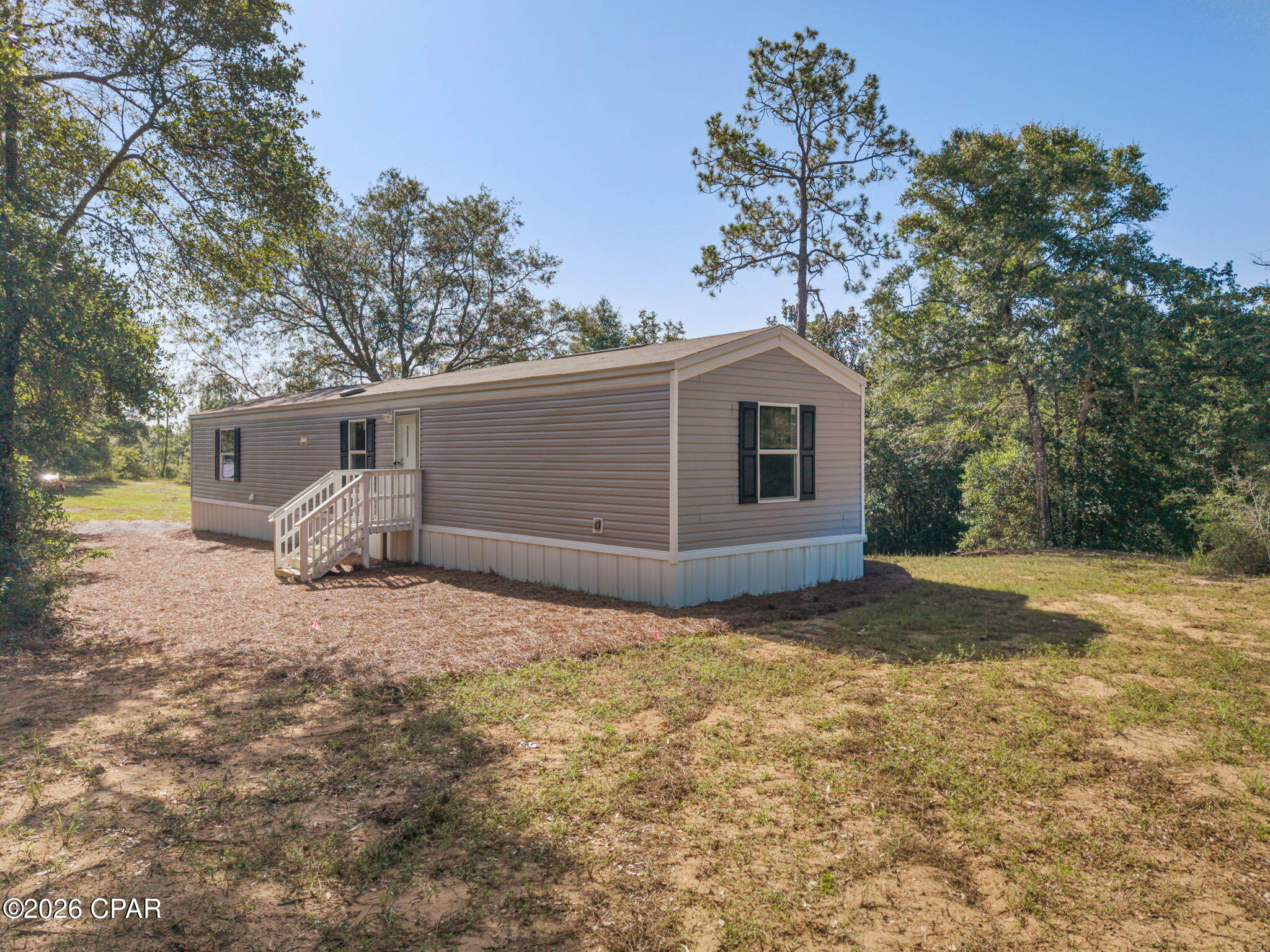Nestled on approximately 1.2 acres of wooded land, this 3-bedroom, 2-bath home offers the perfect opportunity to enjoy peaceful country living. With a functional split-bedroom floor plan and an open living area, this home provides a comfortable space for everyday life. The spacious living room flows into the kitchen and dining area, where you'll find ample cabinet and counter space, black appliances, and plenty of room for preparing meals and gathering with family or friends. Just off the kitchen, a dedicated laundry area adds everyday convenience. The private primary suite is situated separately from the two additional bedrooms and full bath, creating a layout that works well for families, guests, or a home office. Outside, the property is surrounded by mature trees, offering privacy and plenty of room to enjoy the outdoors. If you're looking for an affordable home with land and a peaceful setting, this move-in-ready property is ready to welcome its next owner. Schedule your private showing today!