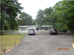 1.8 acres with 3/2 well maintained mobile home approximately 7 miles from Panama City Mall. This home has newer carpet with most of the furniture remaining along with a washer & dryer. According to the Seller the driveway is about 6 months old (nice & large with plenty of parking area), thermostat replaced about a month ago, water heater replaced about a year ago, new metal roof & window A/C never used. Yes, there is central heat & air and a carport with concrete & an attached workshop 14X20 complete with lots of work benches. Septic tank was cleaned in February according to the Seller. There are two covered porches and a large concrete patio to entertain on. Each of the three bedrooms has an exterior door for added safety. This home is priced for a quick sale so do miss out-make