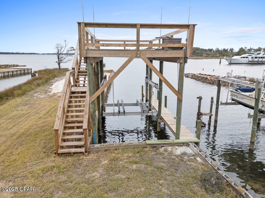 MOBILE HOME HAS BEEN REMOVED FROM THE PROPERTY! This fisherman's playground is ready for your boat! Making memories out on the water, sunbathing on the upper deck, watching Tyndall Air shows, and taking in the coasts gorgeous sunsets could be your reality with this property. It is one of the only lots along the bay that you can back your truck up to the boat dock to load and unload all of your gear (and fish!) conveniently. The lift can handle 16,000 pounds of boat with a 30 foot long dock (can be lengthened). It is currently set up for a catamaran but can be adjusted to fit most boats. This rig comes fully equipped with a fresh water wash down and motor flush. Electricity is ran to the dock for your convenience and the top deck has poles for a removable sun shade! This has all been added by the seller as well as repairing the seawall and bringing in sand to build up the area. There is a shed on property as well. Plenty of room for boat parking or storage and the property is partially fenced if someone wanted to gate the property in. Property is within a mile of the boat launch. Enjoy short trips to Shell Island or Panama City Beach right from your backyard! Location is everything!