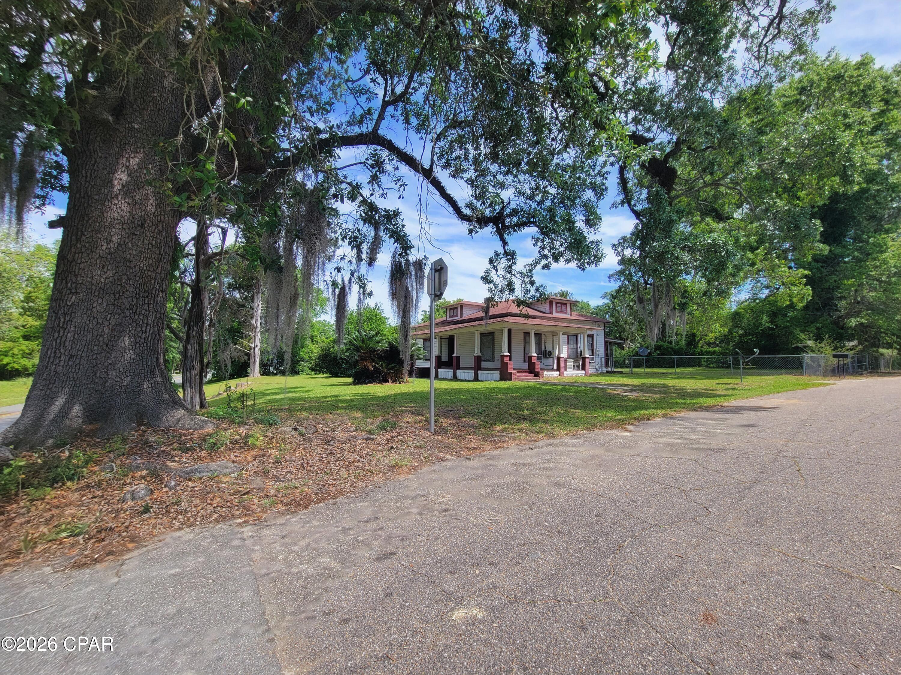 Step into timeless Southern charm with this beautiful 1910 home, perfectly situated on a stunning corner lot just over an acre. Surrounded by mature cedar and oak trees, the setting offers shade, character, and that classic front-porch feel everyone loves.

Inside, you'll find gorgeous hardwood floors, original doors and windows, and unique historic details throughout--showcasing the character and craftsmanship of a bygone era. With four fireplaces, each adding its own charm and personality to the home.

The home features 2 bedrooms and 2 bathrooms, including a charming clawfoot tub that adds to its vintage appeal. Recent updates include a new septic tank and two new (2025) mini-split systems, along with three additional window units for flexible climate control.

Out back, a 10x12 shed provides extra storage or workspace, along with a fenced area perfect for dogs or pets. The property is also equipped with two septic tanks--offering added functionality and potential.

The parcel may also offer future flexibility, as it can potentially be split into two lots with approval from the city commissioners, and the property allows for mobile homes--making it an attractive option for a variety of uses or investment opportunities.

Located within walking distance to Southern Fields Brewing Company and just a block from Highway 231, you'll enjoy convenient access to Panama City Beach or Dothan, AL while still having the space and tranquility of country-style living.

This home is being sold as-is and offers a wonderful opportunity for the next owner to restore and bring it back to its original beauty.

A truly unique Southern beauty--homes like this don't come around often.