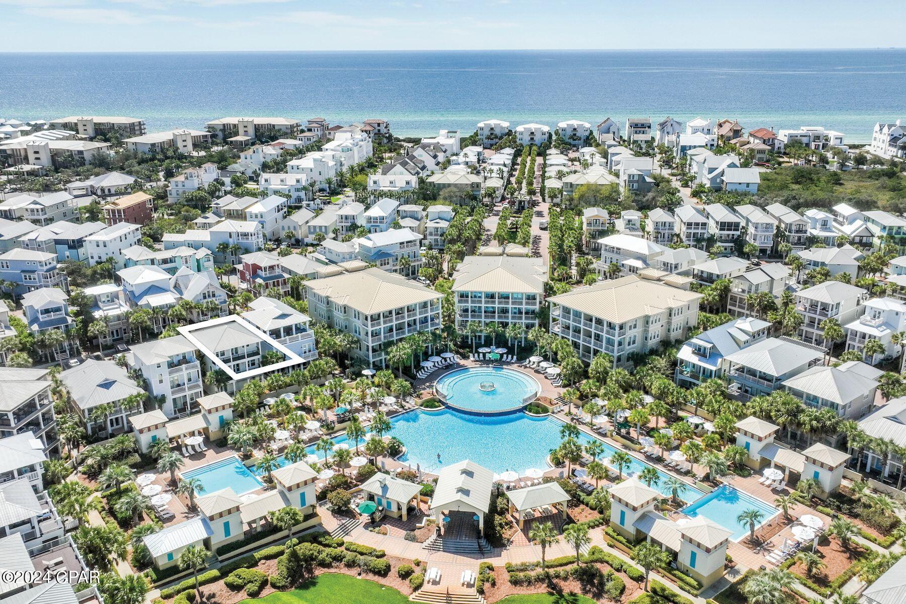 This spacious five-bed, four-bath beach house is superbly located overlooking the 12,000-sq.-ft. lagoon pool in the heart of Seacrest Beach. Set back behind palm trees, it enjoys its own privacy yet is just a stone's throw from the interconnected pools and fountains at this fun-filled oasis. From the coveted two-car garage on the first floor to the generous top-floor open terrace, this home was built for relaxing vacations and togetherness. With a little updating, this property could be a great investment for rental income or just to enjoy with family and friends. Balconies on the upper floors allow everyone to find their own quiet space. The second-floor has an inviting open kitchen, dining and sitting area for gathering around the TV for movie nights, board games or leisurely dining. Extra guests can be seated at the adjoining breakfast bar, perched at the kitchen island or dine outdoors on the balcony or patio. The kitchen is fully equipped for preparing meals and snacks for hungry diners after a fun-filled day at the pool or beach. Head to the third floor terrace for sunning, sunset drinks or stargazing in the gentle sea breeze. This beautiful private haven looks down on the surrounding community. Bedrooms include two master suites, one on the second floor with a private balcony and ensuite bathroom, and the other on the third-floor with ensuite bathroom and attached bunk room which leads out to a peaceful balcony overlooking the pool. An additional first-floor bunk room shares a Jack-and-Jill bathroom with another bedroom with both having pool views and private patio leading out to the pool area. This well-located home has ample parking on the paved driveway and in the two-car garage which also provides storage for beach chairs and pool toys. There's a paved patio for barbecues at the rear of the home. Conveniently close to deeded beach access and tram stops, this spacious residence is at the front of the development making walking or biking to the renowned shops and eateries along 30A a breeze. Enjoy walking paths throughout the neighborhood and designated green spaces for pets, bocce ball, reading, or play areas for children as well as outdoor entertainment, farmers markets, and many amenities at Alys and Rosemary Beaches. This home offers the perfect blend of luxury and convenience. Buyer should verify all data and dimensions if important.