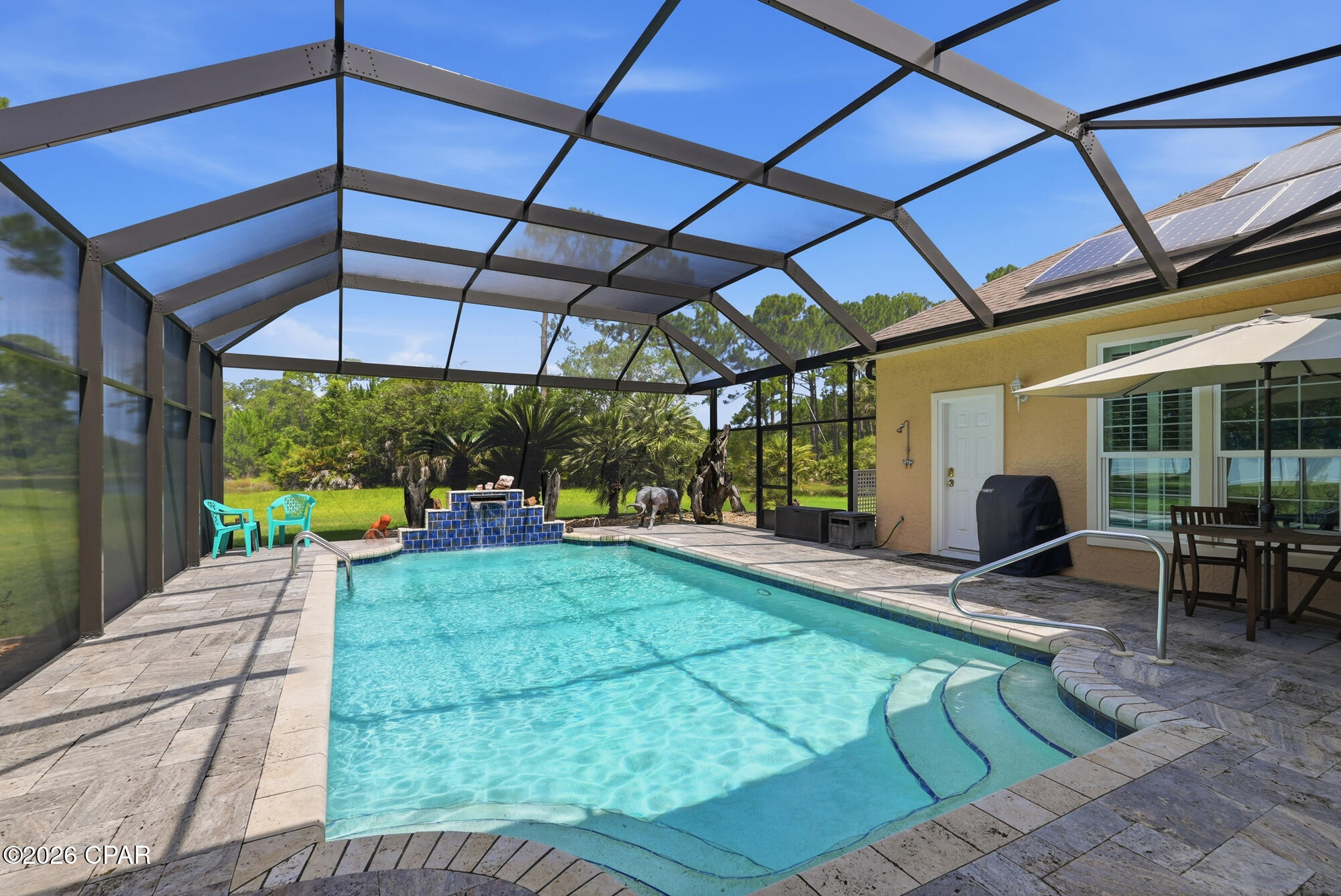 Custom Construction combined with Coastal Comfort in THE GLADES, Panama City Beach, Florida...
One fifty-two Grand Heron Drive is an exceptional, custom-built residence which departs from the mass-produced, offering craftsmanship and architectural detail designed for secure and tranquil living, all with a large saltwater pool, Sundance Spa, idyllic water views -- AND all on ONE LEVEL. This COMFORTABLE home with its split bedroom floor plan showcases OPENNESS as soon as you enter the handsomely landscaped, large CIRCLE driveway. Step inside the beautiful leaded pattern-glass door and observe porcelain tile throughout the home, a flowing floor plan that displays the elegance of high ceilings, crown molding, 2x6 construction, deep PLANTATION SHUTTERS, arched openings, and LOTS of LIGHT! 
HVAC is a 2023 Trane 4-ton and Trane 5-ton heater which is enough energy to heat and cool this large high ceiling home.  SOLAR PANELS were bought and installed in 2015 and have 28 panels making enough electricity to accommodate at least half of monthly FPL bills. The Panels are on a Wi-Fi program aligned with internet that shows if any panel is not producing.                         
A new wind mitigation report showing hurricane improvements has led to significant insurance savings with a new insurance company. All standard doors, French doors, garage doors, and windows are hurricane rated and very durable...never have to be painted. The acrylic block bathroom windows all have hurricane rated panels that are easy to put up, and the beautiful stained glass and wood front door has hurricane rated fabric that is also easy to install. All doors have new Schlage locks with key or keypad access. The LARGE MAIN LIVING area includes a FIREPLACE, updated with a Dimplex electric insert and lighted, built in glass display shelves to showcase your exquisite collections. LARGE formal dining space opens into the living area with French door views to the pool. The PRIMARY suite showcases a seating area, two walk in closets, a large light-filled bathroom with separate vanities, and both a tub and spacious shower. The three bedroom guest wing adjacent to the family room has a Leaf antenna as a second Wi-Fi connection . Don't need a fourth bedroom? A generous area includes a LARGE, flexible-use room that might serve as an office for TWO and/or an area for artists to create.  
The KITCHEN has BEAUTIFUL CABINETRY, wall oven, and an ISLAND that includes a BREAKFAST BAR and PREP SINK. A Simplisafe moisture detection system is in place and on a 24 hour monitoring system under sink and water heater. The space flows to a breakfast nook then into the FAMILY ROOM with easy access to the pool deck. The laundry area is large with storage closets, extra refrigerator, and the built-in ironing board. Now out to the LARGE, screen-enclosed pool accessible from several points in the home...with plenty of surrounding space for poolside dining and lounging. The pool is heated, has Hayward equipment, and with its copper lines, chlorine use is minimal. The 2025-installed screen POOL ENCLOSURE enhances the picturesque pond views. Rain gutters and a sprinkler system that includes adjustable bubblers are in place. The 4393 sq ft under roof includes GARAGE spaces FOR VEHICLES, golf cart, and/or work tables and equipment. With a location SOUTH of the soon to be six-lane Panama City Beach Parkway ...sooo close to the beach, this home and beautiful community with its LOW fees which includes trash pick up are within minutes of the Sugar Shore and Emerald Waters with three major access points, two at lighted intersections for safety and convenience. Shopping, fine and casual dining, medical facilities including a NEW branch of Tallahassee Memorial, and entertainment are minutes away. All levels of school are nearby as is Gulf Coast College AND a branch of FSU. DUPLIN Winery and it's LIVE MUSIC and beautiful gift shop is just a golf cart ride away! Come join the fun!