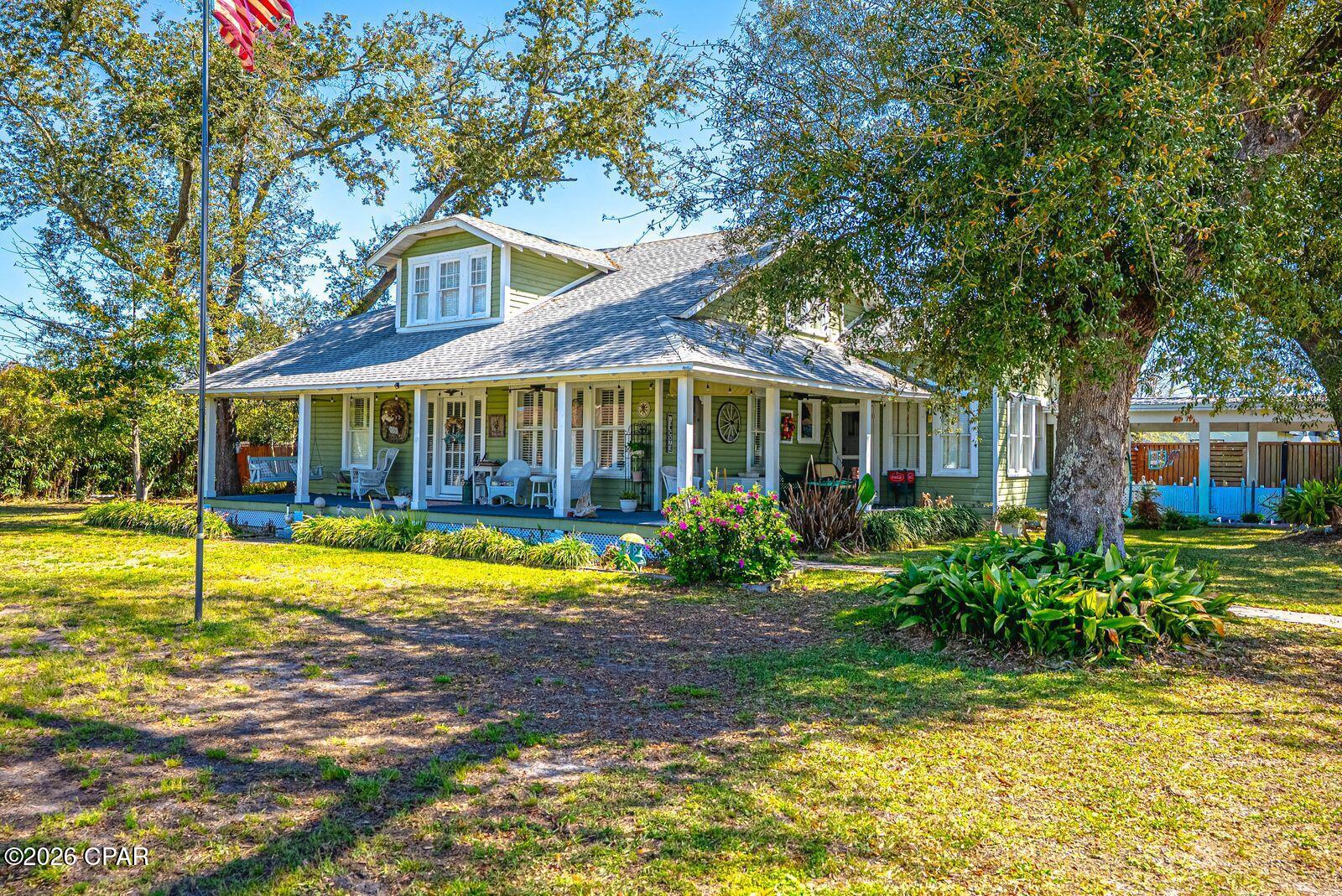 This wonderful historic Florida home sits in the desirable Cove area and only one block from the beach and Beach Drive.  Home is close to  3000 square feet to accommodate a large family. Major renovations were accomplished in 1980 and 2010 with upgraded electrical, new wiring, and plumbing.  A new kitchen with numerous upgrades, large family bonus room added, and other factors.  Home is a 4 bedroom and 4 full bathrooms sitting on over 1/2 (0.67) of an acre with some water view visibility of the Bay.  The true elegance of this home is indescribable with so much character, history, and personality. Approaching the circular drive way, surrounded by a wrap around porch, you are entering the  elegant entrance and  greeted by original hard wood flooring throughout, thus  encompassing a formal living room and formal dining room.  Large Master bedroom and spacious bathroom all  located on the 1st floor.  Also on the 1st floor is a guest bedroom.  The large kitchen has been fully upgraded with stainless steel appliances, granite counter and breakfast bar.. Kitchen overlooks the Family Room which is surrounded by numerous windows giving natural lighting throughout . Ample pantry and laundry room.  You have a large spacious bonus room that can by used as an office, play room, game room or another Family room.  Walking up the second floor, you have two large bedrooms and two additional full bathrooms.  The exterior is beautifully landscaped with a circular driveway for your parking needs.  You have  a beautiful fenced in back yard,  A workshop, garage and room for a golf cart gives you plenty of room for parking to include a RV.. This large home combines timeless comfort and close proximity to the beach, schools, shopping, fine restaurants in the  St Andrew area.  Original build date is 1920 and Effective Build date is 1986.  Home sits on 067 acres which is combined two lots.  All measurements, and information must be verified by Buyer or Realtors Buyer.