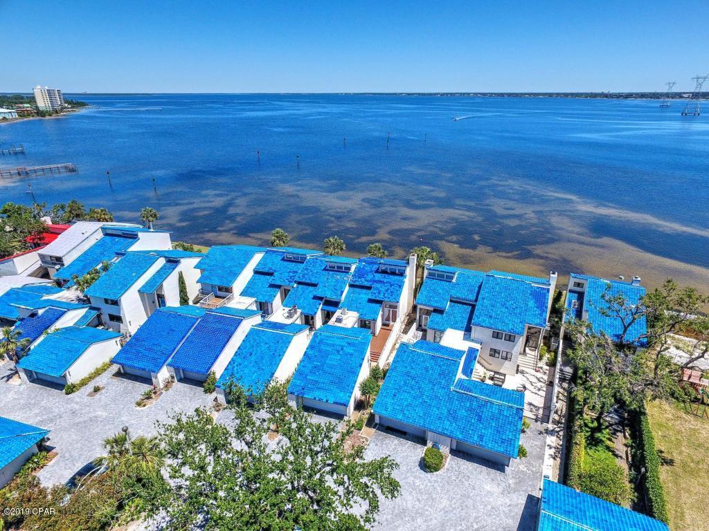 Enjoy expansive water view of St Andrews Bay from both floors of this two-story townhome. A private marina opposite the bay allows you to dock your boat in a protected lagoon. From the deck of your private bay front patio, you can entertain while enjoying big water views across one of the widest parts of St Andrews Bay. A two-story foyer allow you to property greet guest. Chiseled-edge travertine flooring allows for your choice of décor. Two story living room windows provide ample light. A thoughtful kitchen separates the main living area from the den