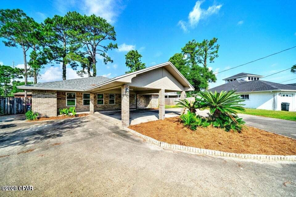 Woodlawn is one of the area's most sought after communities, located along the bay just west of the Hathaway Bridge, Woodlawn affords easy access to St. Andrews Bay, Panama City, and Panama City Beach with limited traffic to deal with.Very close to the sports park and this home has room for a whole team! This beautiful brick home has been updated and remodeled to perfection! Home features 3 bedrooms and 3 FULL baths. The master bedroom is large with a HUGE closet and ensuite bath features large custom tiled shower with 2 shower heads. Home has new energy efficient windows throughout in 2023. Kitchen was just remodeled with new cabinets, quartz countertops and new fixtures. Home has durable ''wood-look'' tile, carpet in each bedroom, and a brick wood burning fireplace. Home has a new roof in 2023, a LARGE covered carport with circular drive and many other updates! To view property, please text a copy of your drivers license to the office number and we will get you set up with a showing within 1 business day.
