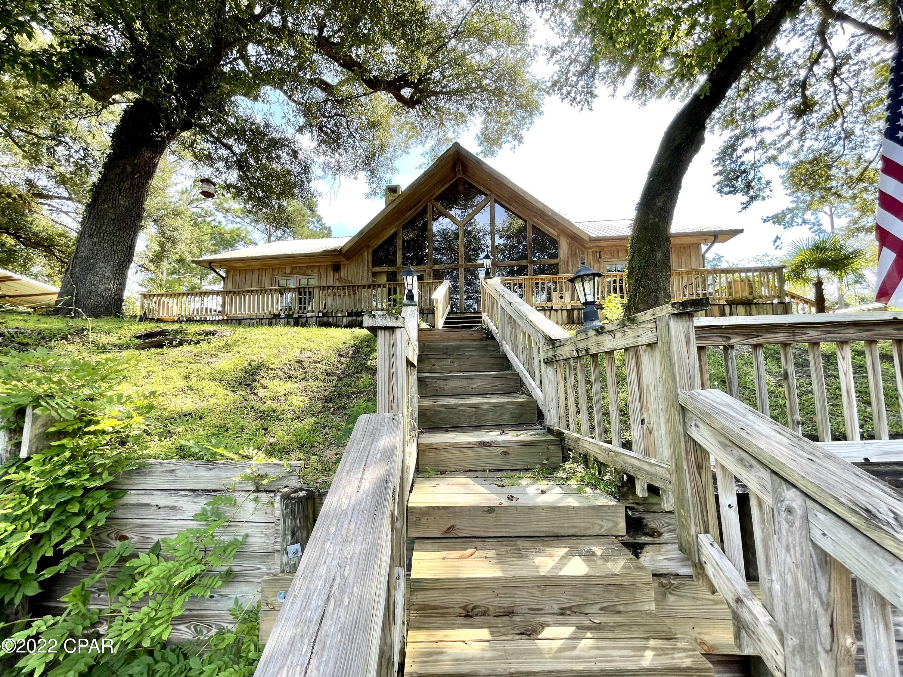 CURRENTLY UNDER CONTRACT, SELLER WILL CONSIDER BACKUP OFFERS.  Chipola River DREAM HOME!!!! This remarkable waterfront home has about 190 feet of river frontage! This yard is fenced and landscaped with a full sprinkler system. The main home is 3/2 with the most beautiful interior imaginable. Your new living area features cathedral ceilings with recessed lighting and huge picture windows to look out at the water. There is a wood burning fireplace and all cozy hardwood flooring and wall finish. The kitchen is equipped with a wine cooler, brand new propane gas stove and state of the art refrigerator, an island, and plenty of cabinet storage! The master bedroom has it's own access to the waterfront porch and a large master bath with double closets, separate vanities, a tile shower, AND a garden Outdoors you will find a game cleaning/cook shed completely set up for the avid outdoorsmen and women! Next to the main home, you'll have a two car carport, one car garage, a laundry room with storage and a full bathroom!! Attached to the carport is also a separate suite with a full living area, bedding for two, and a full bathroom. This home requires no flood insurance, access to two private boat landings, and a full two level boat dock. This place has so much to offer it's absolutely impossible to list it all. Make an appointment to see it NOW!