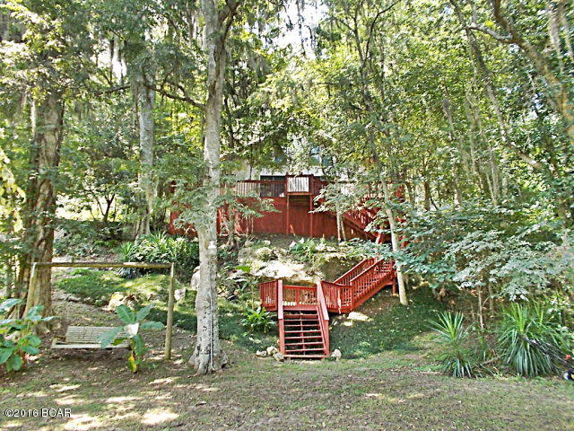This unique home is the last house on the water just around the bend from the head of Blue Springs where the daily average flow from one of the many underwater caves is 77 million gallons of crystal clear water.. a true treasure!Fishing, swimming,snorkeling,diving,cave exploring,canoeing,kayaking,paddle boarding,jet-skiing, and pontooning are one step off your dock, or just enjoy relaxing on your treehouse deck shaded by natural foliage of oak,bay, and cypress along with banana trees, elephant ears, and wild river fern growing in the limestone crevices.The metal roof,wrap around deck and exterior stairway have been replaced within the last five years.The entry side of the home was uniquely chair-railed in 30 year roofing shingles against cedar siding to give a lap board look. The den and loft features 18 ft stained bead board ceilings,along with original pine floors with ceramic tile in the laundry and 1/2 bath and slate tiles in the main bath. The house is all electric,with central heat and air, wood burning fireplace featuring river rock and flint. The mantle is primitive rough-hewn from 100 year plus Cypress tree downed in an old local cemetery. The fireplace is flanked by aluminum clad wood patio doors on either side overlooking the tree lined deck and mill pond.The current owners have maintained a termite contract the entirety of their 15 year residency with annual inspections and no signs of termite damage or infestation. This home is truly one of a kind.