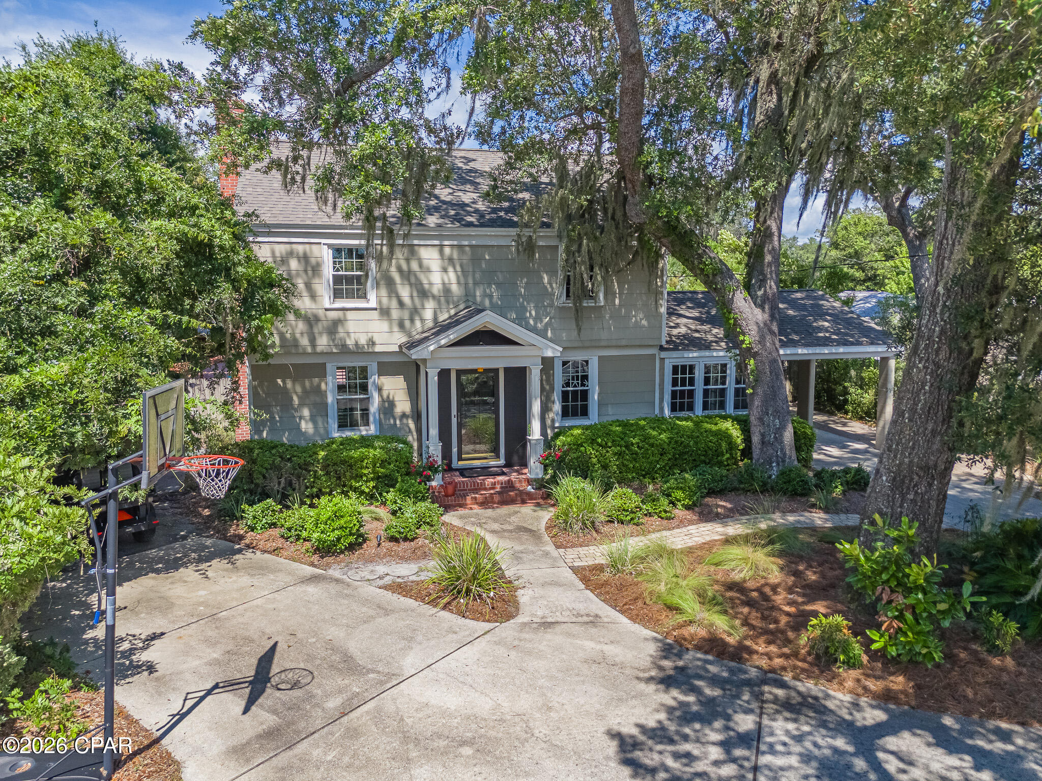 Welcome to 427 Bunkers Cove Road, an exceptional coastal residence located in the highly sought-after Cove neighborhood of Panama City, just moments from St. Andrews Bay and around the corner from the St. Andrews Bay Yacht Club. This prime location offers the perfect blend of waterfront living and convenience, with downtown Panama City, restaurants, shopping, and local attractions only minutes away.
Offering approximately 2,900 square feet of thoughtfully designed living space, this beautiful Colonial Revival home features 4 bedrooms, 3 full bathrooms, and timeless architectural character throughout. The inviting two-story design showcases a symmetrical façade, welcoming columned portico, classic brick chimney, and mature live oak trees draped with Spanish moss, creating unforgettable curb appeal.
Inside, you'll find a spacious and functional floor plan enhanced by hardwood flooring, abundant natural light, divided-pane windows, and stainless steel appliances. The chef's kitchen flows seamlessly into the main living areas, making it ideal for everyday living and entertaining. A bright sunroom overlooks the backyard and provides the perfect space to relax year-round.
Upstairs, a hidden bonus/game room tucked off the fourth bedroom offers endless possibilities as a media room, playroom, home office, or guest retreat while enjoying views of the pool and backyard.
Step outside to your own private oasis featuring an in-ground swimming pool, spa, beautifully landscaped grounds, and multiple areas for entertaining or unwinding. Alley access provides ample parking for a boat, RV, or camper, while the large detached workshop offers outstanding space for storage, hobbies, or recreational equipment.
Additional features include a whole-home water filtration system, covered side carport, established landscaping, mature shade trees, and a golf cart-friendly neighborhood that enhances the relaxed coastal lifestyle.
Combining timeless architecture, modern comforts, generous indoor and outdoor living spaces, and an unbeatable location, 427 Bunkers Cove Road presents a rare opportunity to own one of Panama City's most distinctive homes. Schedule your private showing today and experience everything this exceptional property has to offer.