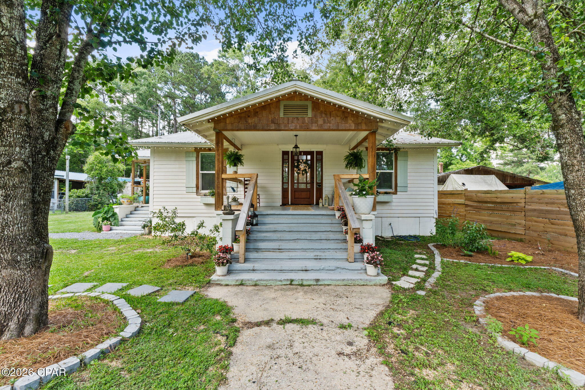 This is where country living meets convenience! Located just beyond the city limits of Bonifay, this homestead is ready for its new owners. Don't let the first glimpse fool you. This property is large, equipped, and ready for you and your animals. Beyond the 3 bedroom 2 bathroom farmhouse-style home is 7.91 acres, 20x36 pole barn walled up with a slab, 40x40 barn with electricity and stall, greenhouse, chicken Coop, fenced and cross-fenced pastures with water connections throughout, multiple garden areas (raised beds and in-ground), outdoor shower, fruit trees, a wooded area with trails for ATVs, and a spring-fed pond stocked with Bass, Bream, & Catfish. The home itself has been updated with a metal roof in 2017. The entire home was renovated in 2020 with continuous update since, to include new wiring, plumbing, tankless water heater, shiplap walls/ceiling, subflooring, windows, fixtures, hardware, doors, bathrooms, flooring, and more. The kitchen features stainless appliances to include a, dishwasher,  gas burning stove, freezer, wine cooler, and two compact refrigerators. It also features custom cabinetry which gives the home a unique feel and ties it together with a gorgeous wooden island top. The primary suite is open and airy and walks right out to the back porch. Relax on the porch or enjoy the evening by the fire pit out back.  The fireplace inside the home is wood burning, but has never been used- functionality is not guaranteed. This property isn't located in the city limits, but it is serviced with city sewer and water. Located less than an hour from Panama City Beach, it is a quick drive to hop over to Highway 79 and enjoy a beach day!