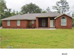 Beautifully appointed home in the Village of Spanish Lakes subdivision. This 3 bedroom, 2 bath home features a brick front with vinyl back and sides. Wooded lot and side entry garage offers privacy and seclusion in this modern home. This lot goes all the way through to Lucas Lake road for quick access to the lake and public boat ramp. As you enter the front door, you will see a beautifully tiled foyer. The living area boasts 11 foot ceilings with fan and recessed lighting. A set of French doors with integrated mini-blinds opens onto the covered porch area and into the spacious back yard. The kitchen features all wood maple cabinetry, granite-look countertops and breakfast bar with stainless steel appliances. The dining room provides an informal space, with plenty of room for