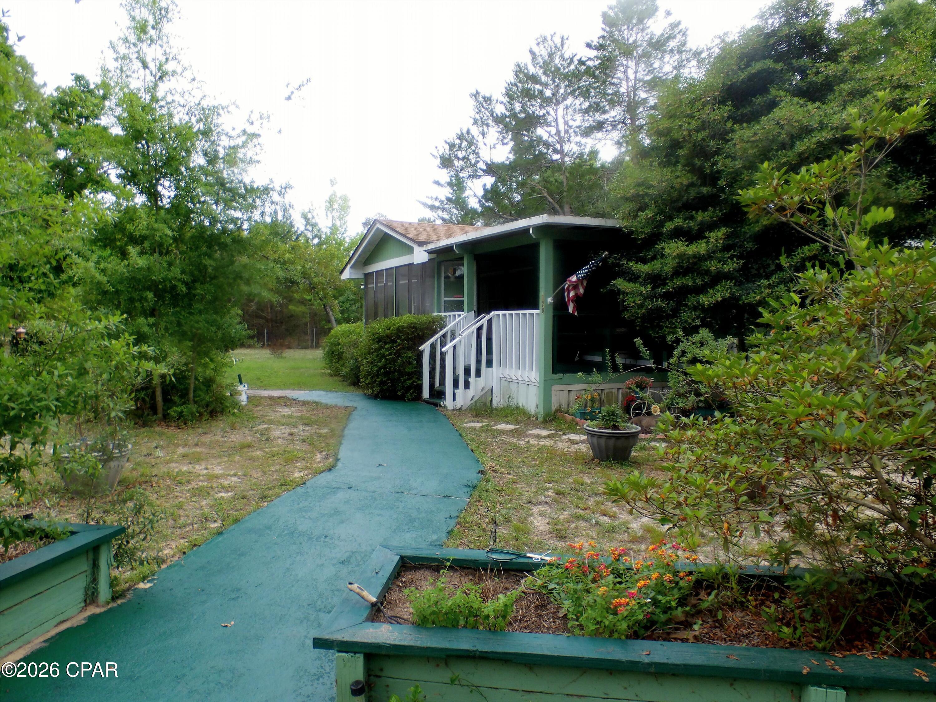This property has a lot to offer.  The main structure is a three bedroom two bathroom manufactured home on a 2 acre lot.  The home is on lot down from a paved road, and is close to Bozeman  Learning Center. Lynn Haven and Panama  City  The home features two porches and Florida rooms one heated and cooled.   The property includes a three car carport,  a 12 x20 shed with lean to,  12x8 storage shed, 8x40 Conex storage and an older  2 bedroom one bathroom home used a rental.