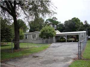 Great curb appeal brings you to this well maintained triple wide manufactured home located near Tyndall Airforce Base, situated on a completely fenced large yard. This home features a living room with a fireplace, dining room, huge eat in kitchen. Split floor plan with a spacious master bedroom and bath with a garden tub and separate shower, two guest bedrooms and bath. Two car, carport with an air conditioned storage, 1 car detached block garage/workshop, extended driveway will accommodate several vehicles. Several mature fruit trees in the backyard. This affordable home is a pleasure to show, don't miss it.