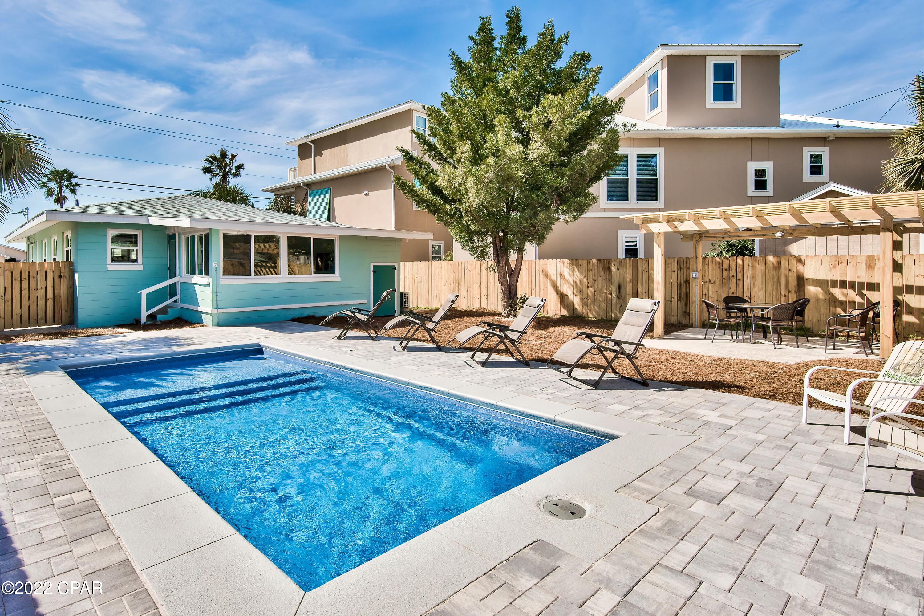 VACANT LOT INCLUDED! Enjoy the beach from the coveted west end of Panama City Beach from this three-bed, two-bath home that also INCLUDES the vacant lot directly behind the house. (The home, only, is also available for purchase for $1.35M). This 1,360-sq.-ft. retreat is situated directly across the street from two public beach accesses and has its own brand new, private heated pool that can be controlled via smartphone app in the fenced backyard. Investors will appreciate the versatility of this listing, such as building on the rear lot while renting the front or selling the home and building a new structure on the empty lot. The home was completely renovated down to the studs and features all-new wiring; new plumbing, new LVP flooring; a custom kitchen with bar seating, quartz countertops and new stainless steel appliances; custom baths with designer tile and new plumbing fixtures; new insulation; new tankless water heater; new hurricane doors and windows; new washer/dryer; and, an enclosed heated and cooled porch with all new windows that overlook the pool and backyard with pergola and grilling area. The interior of the home has an inviting open-concept floor plan decorated in a modern beach theme. The spacious living room leads to a dedicated dining area with seating for six. The owner's suite features an en suite bath with curved shower stall. Two additional bedrooms are available, including one with king bed and one with twin-over-full bunks. Old Florida cottage-style charm awaits in this retreat, which is conveniently located just five miles from Pier Park and a short drive to Rosemary Beach, WaterColor and Seaside, Florida, with all of the dining, shopping and entertainment options that Scenic Highway 30A has to offer. This home is sold fully furnished and is rental ready. Buyer to verify all information and dimensions.