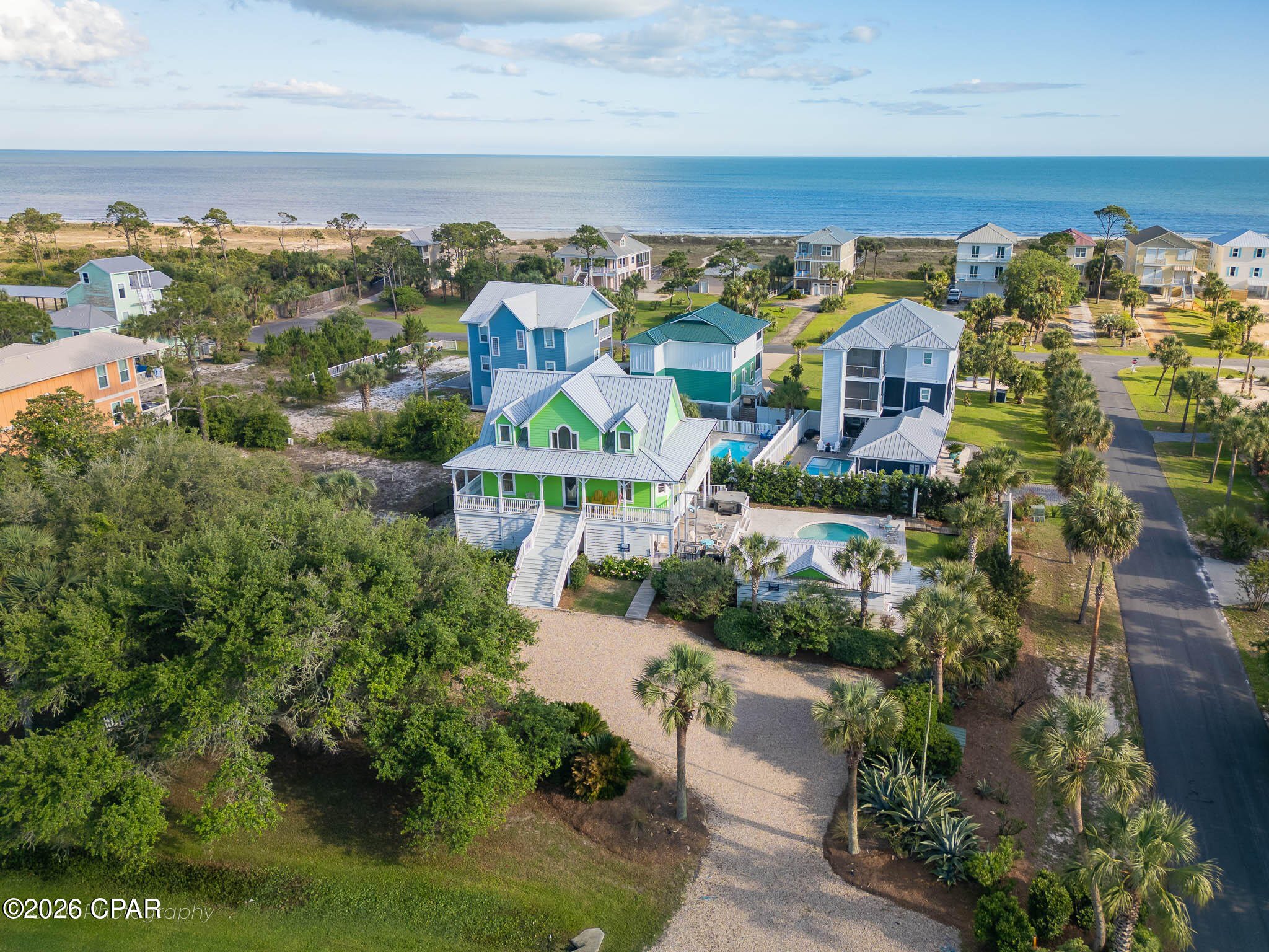 Discover the Forgotten Coast at its finest in the highly sought-after Two Palms, a Gulf front community on Cape San Blas. This stunning 6-bedroom, 4-bath retreat offers 3,245 square feet of elevated coastal living, built for unforgettable gatherings and effortless relaxation. The resort-style outdoor oasis steals the show with a private pool, soothing hot tub, covered pavilion with gas grill, gas fire pit, and hot/cold outdoor shower, creating an entertainer's dream beneath the swaying palms. Three levels of thoughtfully designed living space accommodate 15+ guests. The second-floor great room is the heart of the home, with open concept living, dining, and kitchen areas bathed in natural light. A king primary suite with en suite Jacuzzi tub and private deck access serves as a true owner's retreat, while two additional king suites upstairs and queen and bunk rooms below offer flexibility for multi-generational getaways. A media room, lift elevator, EV charging, and parking for five round out the home. The location is unbeatable. Two private community beach boardwalks sit just a short walk away, delivering you to sugar-white sands and emerald Gulf waters. Directly across the street, Salinas Park offers immediate access to St. Joseph Bay, a kayaker's and angler's paradise, along with the Serenity Trail for sunset bike rides and scenic walks along the bay. Stroll to Scallop Republic for bayfront music and cocktails. Beyond your doorstep, T.H. Stone Memorial St. Joseph Peninsula State Park sits five miles away with pristine shoreline and hiking trails. Historic Port St. Joe offers boutique shopping and waterfront dining, while Indian Pass, Apalachicola, and Mexico Beach serve up the freshest Gulf-to-table seafood in the South. Whether you seek a turnkey luxury second home, a proven income producer, or a forever coastal compound, this rare gem delivers. The Gulf is calling you now.