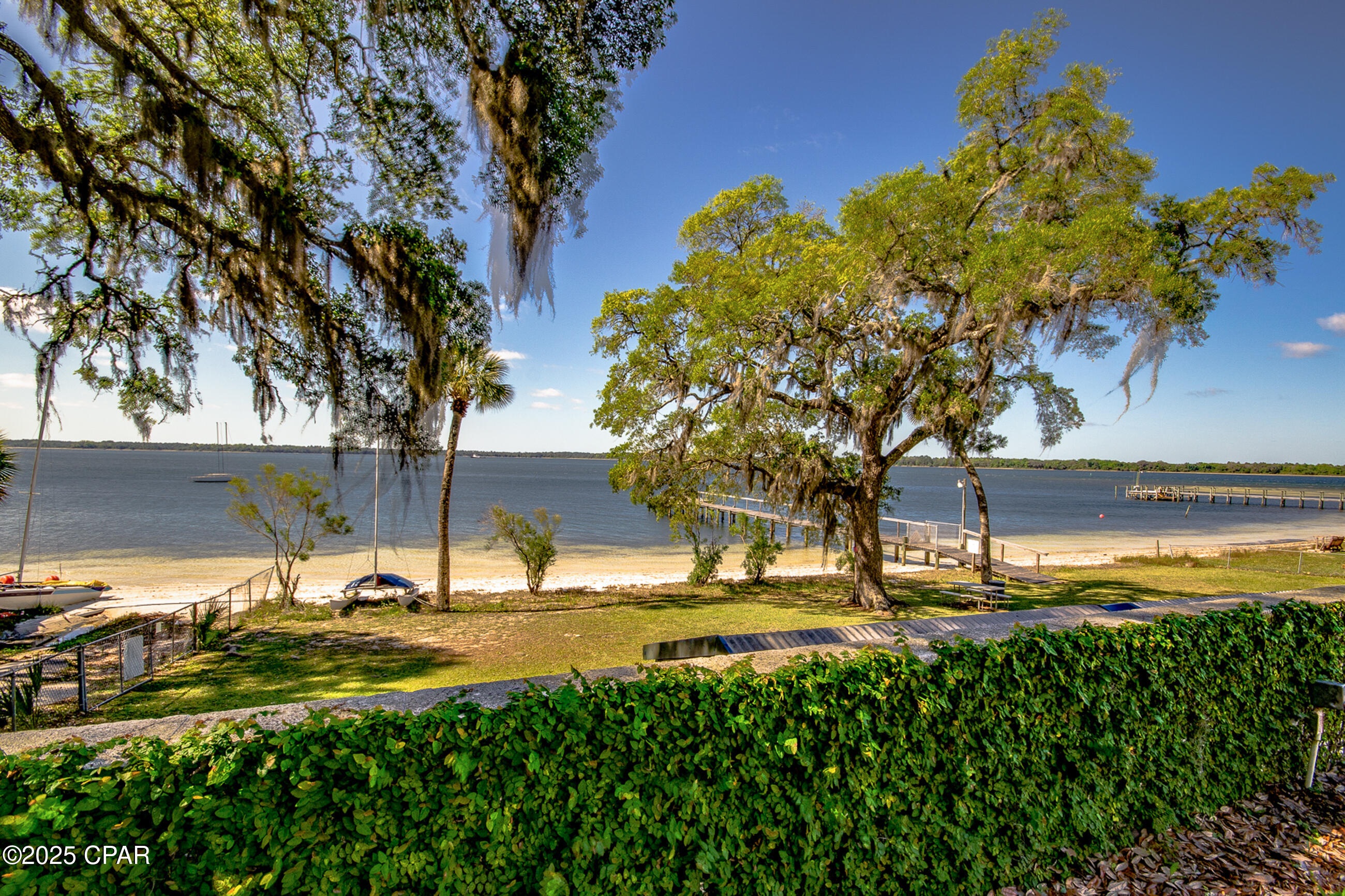 Welcome to Bay Club Condos, a hidden gem located on the scenic shores of historic St. Andrews Bay. This very well-maintained 2-bedroom, 2-bath corner unit offers a rare combination of comfort, convenience, and coastal charm. Inside, you'll find new luxury vinyl plank flooring throughout, a new AC unit, and recent upgrades including a new disposal, hot water heater, washer, and dryer ensuring truly trouble-free ownership. The inviting open floor plan is perfect for relaxing or entertaining while enjoying the natural light that floods this bright and airy corner unit. Located in the highly sought-after Bunkers Cove area, Bay Club Condos offers the best of the relaxed coastal lifestyle all just minutes from shopping, local coffee shops, dining, entertainment, and recreation. Enjoy peaceful bayfront walks, take in beautiful water views, or unwind by the community pool, beach area, or private dock. If you've been dreaming of low-maintenance waterfront living in a quiet, picturesque community, look no further this is the one.