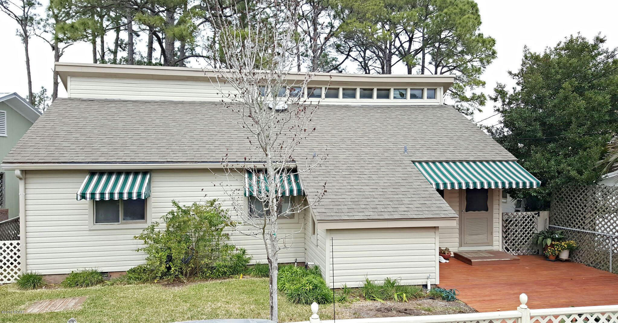 Here it is...Waterfront Living!! This home  has the perfect floor plan to take advantage of the Gorgeous View over looking Grand Lagoon. Large Deck w/ trees for shade in the back yard. Also there is a dock for your boat or jet skis.  Inside there is Pecky Cypress walls that gives this home that cozy Old Florida Cottage Charm . Excellent condition, New Roof & Windows 2012 and New Carpet & New Paint in Bedrooms 2016. Whether it's your primary home or a vacation home...this is a One Of A Kind Home that will add enjoyment to your lifestyle.  Must See!!!