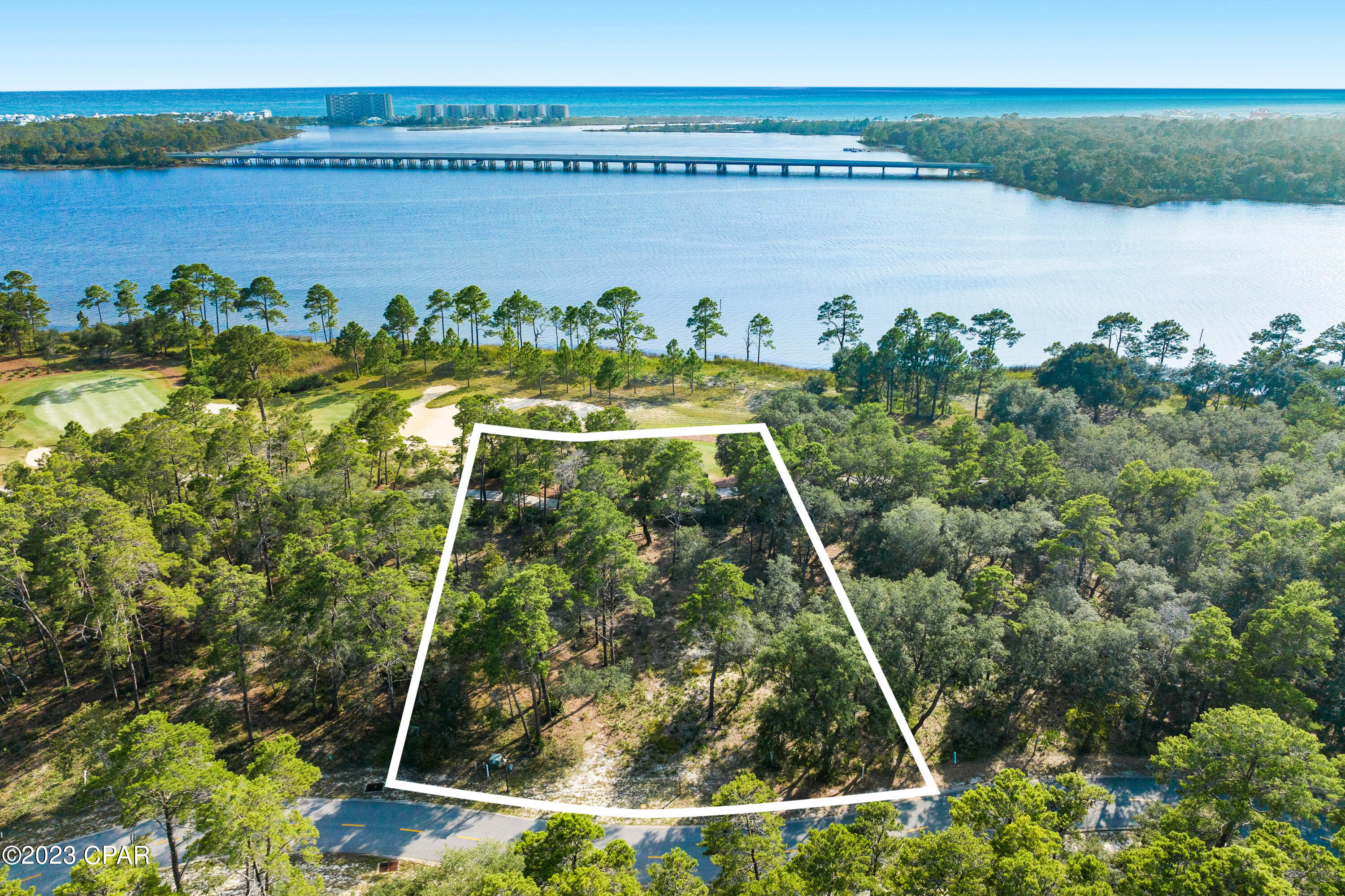 This prime lot is one of only a few of its kind in beautiful gated Wild Heron, a 734-acre coastal sanctuary located on the shores of Lake Powell at Inlet Beach. From the raised elevation, it presides over stunning views of the lake and borders the lush 14th fairway of Shark's Tooth Golf Course. Boasting beautiful mature oaks and magnolia trees, this high and dry lot in the coveted 'Reserve' area, is located in Flood Zone X, making it low risk for insurance. Backing onto the scenic lake and 14th fairway allows for potential views of the shimmering Gulf of Mexico from the upper floors of your new dream home. The sale includes a full survey and two sets of plans for potential builds at a value of over $55K. These will expedite the building process, allowing you to have your dream residence move-in ready in a relatively shorter time span. Neighboring properties with no water views command prices above $2.8 million, demonstrating a clear potential for investors to build and sell for a profit. A gated north entrance to Wild Heron is planned for direct access to the new Origins golf course and development bordering Wild Heron. This will provide access to upmarket Watersound Origins. This new road will eventually connect with the airport and Margaritaville, further enhancing future property values. As well as the top-rated Greg Norman-designed golf course and tennis courts to be enjoyed with the Watersound Club membership, Wild Heron amenities include a lakefront community heated pool and hot tub, fully equipped fitness center, a boathouse stocked with kayaks, a dock, firepit and grilling area as well as 24 miles of biking trails and boardwalks for exploring, as well as a family park at Prospect Point for live entertainment, food trucks and more. The lot is across from the outflow into Lake Powell, Florida's largest coastal dune lake. Owners can paddle by kayak to Camp Helen State Park and enjoy the beautiful white sandy beaches and warm gulf waters or you can launch your boat for the day at the boat launch and spend the day on the lake. Don't let this one slip past you. Call today for a showing. Buyer to verify all data and dimensions.

Note: From Wild Heron entrance is appxs 10 min to 30A and 12 minutes to Pier Park with only 20-25 minutes to the airport. You are within 5-7 minutes to grocery stores, restaurants, pharmacy, storage, gas stations, car wash, pet vet, dentist, Dr's, urgent care and much more!  What more could you ask for?!