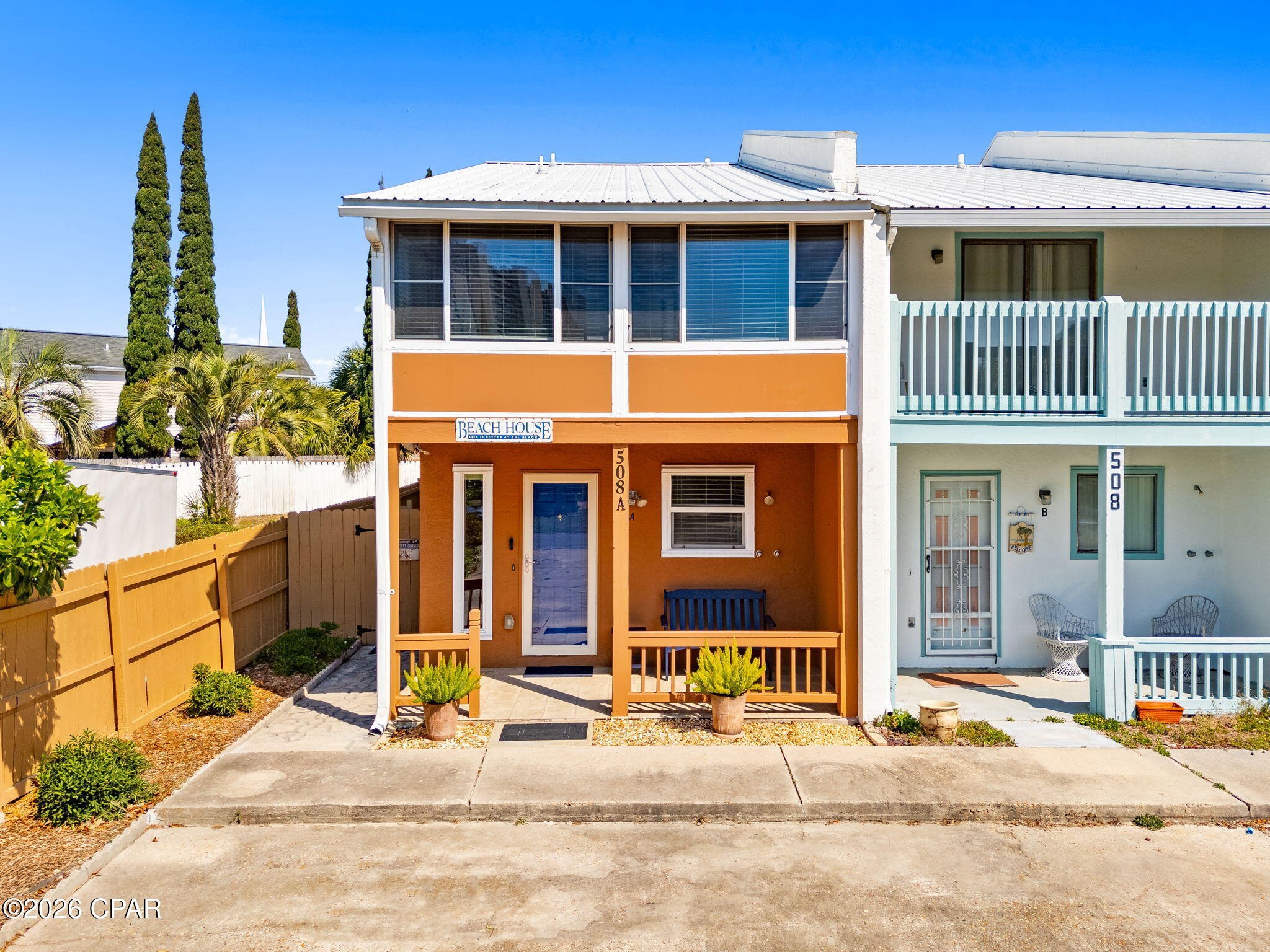 PRICE IMPROVEMENT!     Walk to Beach Access 65! -- no HOA and short-term rentals allowed! Just 0.2 miles from Beach Access 65 and minutes from Pier Park, Frank Brown Park, Harley Davidson, Shopping galore, restaurants and grocery; this 2BR/1.5BA townhouse is a turnkey investment, second home, or primary residence in one of PCB's most vacation-rental-friendly neighborhoods.
     Major updates from 2022-2024 include a new A/C, hot water heater, range, dishwasher, washer/dryer, all new slider doors in the living room, master, and guest bedrooms, and fresh paint throughout -- inside and out, walk-in shower w/seat, master vanity & toilet, microwave, garbage disposal, living and bedroom draperies, new garden shed, printer, Venetian blinds at front & back porches, impact kitchen and foyer windows and an enclosed back porch w/storm door & windows!  Outside, enjoy a fully redone yard, new wooden deck and walkway, and a freshly repaired and painted privacy fence enclosing the back courtyard.  Everything you see in INCLUDED with the exception of the blue bench, stand, palm tree on master balcony, dining room table set, coffee table, flip desk on master bedroom balcony, and owners personal belongings!

The layout delivers two enclosed balconies, a covered front porch, a fully enclosed back patio, wood cabinet kitchen, and a laundry room. Bonus: portable generator, Blink camera system, and doorbell all convey. Rinse off at the outdoor shower and you're home -- beach life made easy.