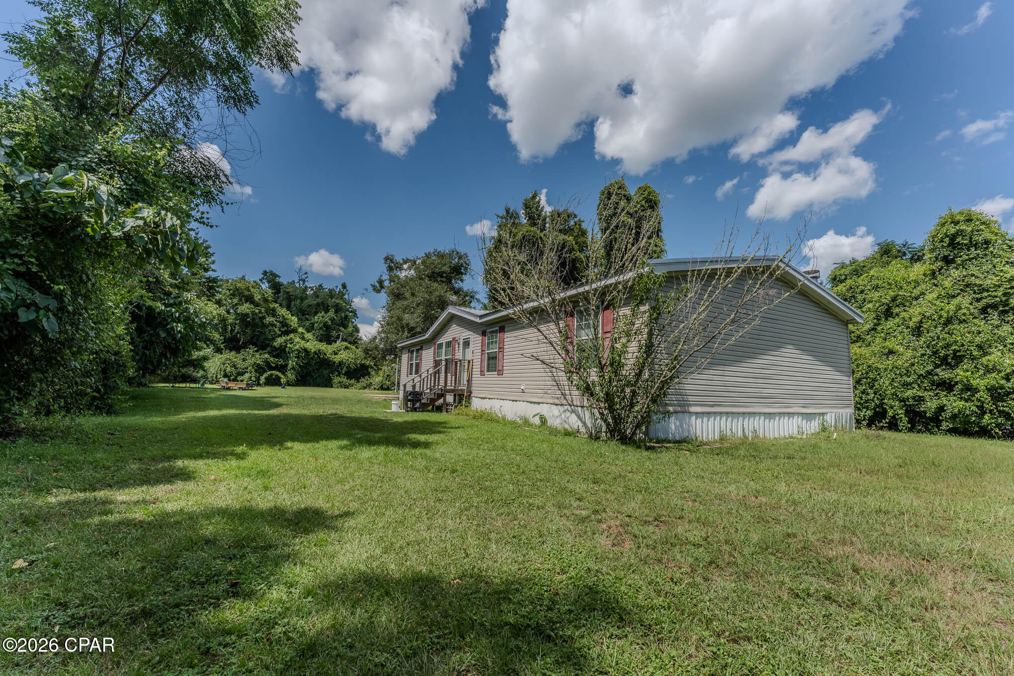 Charming Double Wide on Nearly an Acre - Spacious, Modern, and Move-In Ready! This beautifully maintained three bedroom, two bath home sits on nearly a full acre of land with paved road frontage offering both space and convenience. The split floor plan provides privacy and flow, with two separate living areas perfect for entertaining or relaxing. Cozy up by the fireplace on cool evenings, or enjoy the open layout that connects the living spaces seamlessly. The master suite is a true retreat, featuring a generous walk-in closet and a luxurious en-suite bath with double vanity and a soaking tub - your personal spa after a long day. The kitchen is a chef's dream, equipped with a flat-top cooker and double oven, making meal prep a breeze. With plenty of room to roam outdoors and a functional, well designed interior, this property is ideal for first time buyers, down sizers, or anyone looking for a peaceful setting with modern amenities. Don't miss this gem - schedule your showing today!''