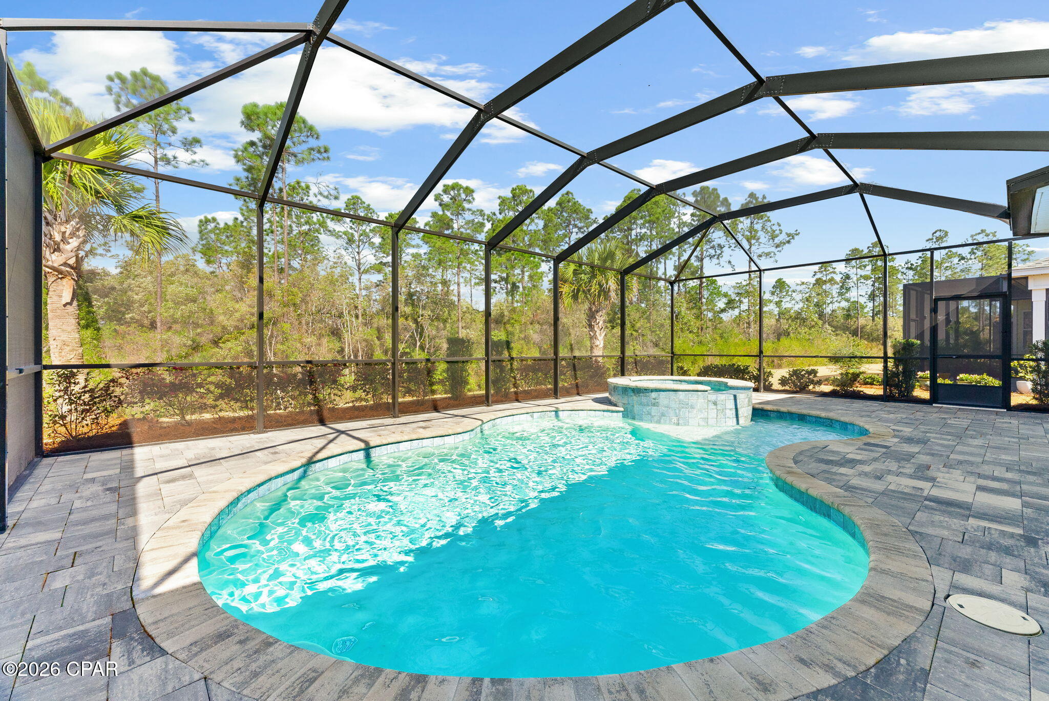 **MOTIVATED SELLER** PARROT WITH POOL - PHASE 4 - CLOSER TO EVERYTHING THAN NEW CONSTRUCTION. Welcome to 8863 Coral Reef Way, a beautifully upgraded Parrot model in highly desirable Phase 4, where many believe you're in the sweet spot of the community. Close enough for a quick golf cart ride to Town Square, yet far enough away to enjoy peace, privacy, and that relaxed island pace of life.

Set on a premium wooded 4B lot, you don't see neighbors behind you -- just natural beauty. It's the kind of backyard where you can sip something cold, listen to your favorite Buffett playlist, and feel like you've permanently escaped the mainland.

And then there's the showstopper.

The SWIMMING POOLl and hot tub are absolutely spectacular. This is not an afterthought pool. This is a full backyard retreat designed for sunset swims, weekend gatherings, and quiet evening soaks under the stars. If Jimmy were writing about a backyard in Watersound, this might be it.

Inside, this Parrot is completely move-in ready and loaded with upgrades:

• Generac whole house generator
•  Quartz countertops throughout
• Extended kitchen counter with matching quartz backsplash
• Upgraded cabinets with soft close doors, crown molding, side panels, pulls, and dual trash cans
• Cabinets, counter, and sink in the laundry room
• Upgraded appliances
• Laminate flooring throughout most of the home
• Upgraded trim throughout

Both bathrooms feature upgraded tile floors and walls, frameless glass shower surrounds, upgraded shower heads, automatic exhaust timer switches, and a no curb entry in the main bath shower for a clean, seamless look.

Additional highlights include:

• Designer lighting over kitchen counters and table
• Whole home WiFi with extender
• WiFi garage door opener
• Epoxy garage floor, shelving, and added attic flooring for storage
• Ring cameras and Yale WiFi door locks
• TV wall brackets and TV outlet plus gas line on the lanai
• High performance ceiling fans
• Custom shelving in the main bedroom closets

Living in Latitude Margaritaville Watersound isn't just about square footage. It's about lifestyle. Resort style pool overlooking the Intracoastal Waterway, a two story full service restaurant, fitness center with indoor lap pool and spa, pickleball and tennis courts, walking trails, kayak launch, bandshell concerts, hobby rooms, and a social calendar that keeps life as full as you want it to be.

And with the St. Joe Company developing the new commercial area along Highway 79, convenience and value continue to grow.

This home captures what the Parrot model is all about -- open, bright, inviting -- with the added bonus of privacy, a spectacular pool, and upgrades in all the right places.

If you've been waiting for your own little piece of paradise where the days move slower and the sunsets last longer, this is it.  Some photos have been virtually staged or digitally altered for presentation purposes
