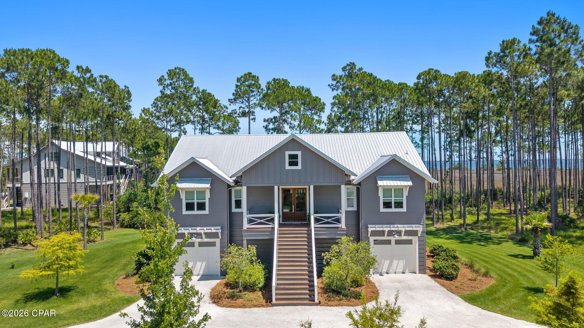 Overlooking West Bay with unobstructed water views, this custom-built residence is set on a premium 0.76-acre corner waterfront homesite with paved road access. The beauty of the setting extends indoors, where designer finishes and thoughtful details create a refined coastal home that feels both elevated and inviting. 

The kitchen serves as the centerpiece of the home, anchored by a Venetian plaster hood, Hallman Majestic gas range, quartz countertops, clay tile backsplash, open cypress shelving, and a dining nook featuring built-in bench seating with storage. A striking cypress beam connects the kitchen and living area, where a Venetian plaster fireplace serves as a focal point against a backdrop of sweeping water views.

Designed as a true retreat, the primary suite pairs scenic water views with custom linen drapery and distinctive wall coverings that add warmth and character to the space. The adjoining bath features Carrera marble finishes, polished nickel fixtures, an oversized glass shower and a freestanding soaking tub. Dual custom closets, including a dressing area with built-in vanity complete the suite. 

The expansive screened porch, complete with a gas fireplace, provides a breathtaking setting to relax and take in the views of West Bay. Thoughtfully designed landscaping complements the home's natural surroundings, with ample room for a future pool or addition. Additional features include an elevator, impact-rated windows, EV charging station, whole-home Generac generator, and finished split garages with abundant storage.

RiverCamps offers a lifestyle unlike any other along the Emerald Coast. This private, gated waterfront community is bordered by West Bay and Crooked Creek, providing direct boating access to Shell Island and the Gulf. Residents enjoy dry boat storage, a community boat launch and day-use slips, a resort-style pool and pavilion, a 600-foot pier, miles of scenic trails and boardwalks, and a fitness center coming soon. Ideally located just minutes from Northwest Florida Beaches International Airport, Pier Park, and the area's white-sand beaches.