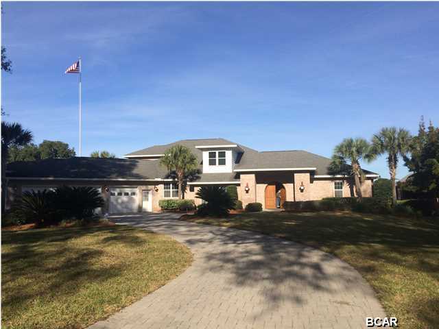 ***PRICE REDUCTION***Top-of-the-line North Bay solid, custom brick home located in Panama Country Club finished with superior materials and craftsmanship. Interior offers: Foyer with tile and hardwood flooring, glass display wall, formal dining room with view of PCC Golf Course, formal living room with bay view and gas double sided fireplace with concrete mantle, oversized kitchen with granite counters, built in refrigerator, double ovens, custom hood vent, wavy granite backsplash, two sinks, wine cooler, walk-in pantry and large serving island, custom laundry room with extensive cabinets, master bedroom with beamed ceiling, hardwood flooring, his/hers walk-in closets, separate shower and bath, and double vanities, family room with beamed ceiling, bay view, and built-ins, office