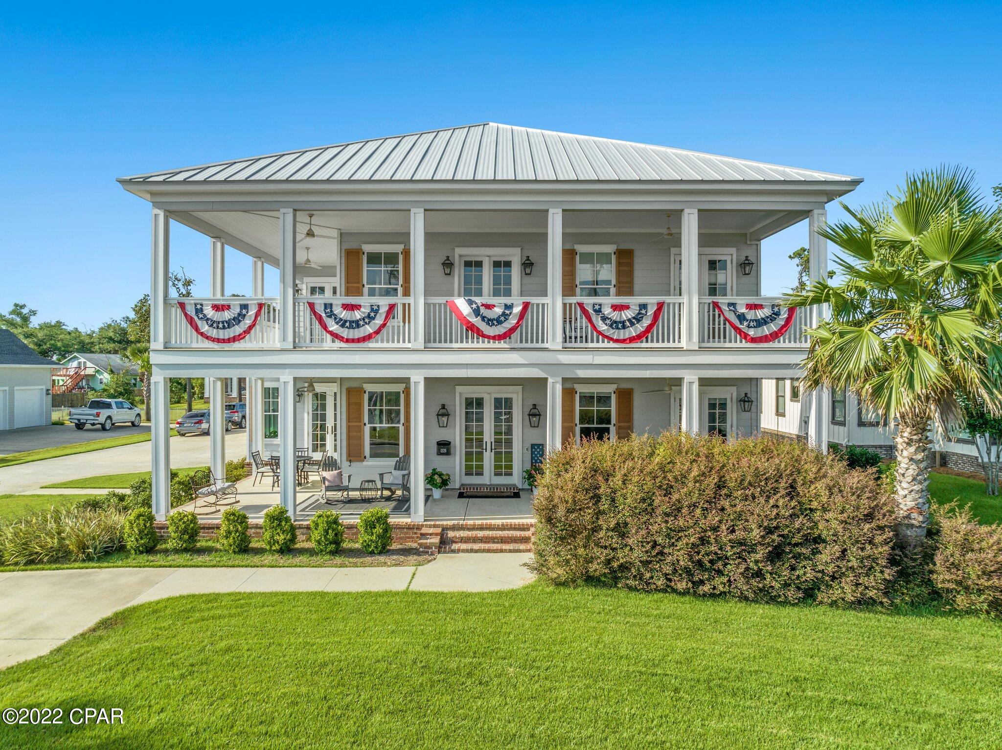 BAYFRONT LIVING! Ideally located within minutes of Downtown Panama City and St. Andrews, this waterfront home is an entertainer's oasis. Outdoor spaces are plentiful with a double wraparound porch, private pool, outdoor shower, gas fire pit with granite top, porcelain tile pavers on pool deck, and outdoor kitchen. The covered outdoor kitchen comes equipped with a gas grill, granite countertop, storage, built in trash, and a half bathroom. 

The interior is immaculately maintained with 10 ft ceilings, engineered hardwoods throughout entire home and includes two separate living spaces, laundry room, wet bar and stair access to attic storage. 

No detail was missed in the stunning chef's kitchen featuring built in appliances, waterfall edge kitchen island, farmhouse sink, and pot filler. Off the kitchen is the breakfast nook with a built in bench and french doors that can open up to an additional outdoor dining area. The main level also includes a formal dining room and a library with beautifully crafted built in bookshelves and 12 ft coffered ceilings. The Owner's Suite is on the first level and has bay views with french doors leading to the front porch. Owner's bath is spacious with double vanities, an elegant claw foot soaking tub, separate tile shower, and walk-in closet. Upstairs is another living space in its own, with a large secondary family room, two additional bedrooms with their own en suite bathrooms, and access to the wraparound balcony from every room. The property also includes the beach lot across the street, no docks are allowed to be built. All important information must be verified by buyer.