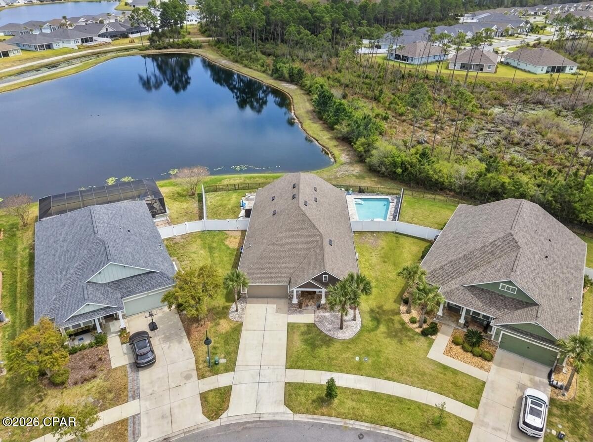 MOTIVATED SELLER - OFFERING $20,000 CONCESSIONS WITH AN ACCEPTABLE OFFER! Waterfront home in Breakfast Point offering approximately 3,200 sq. ft., 4 bedrooms plus a bonus room that can function as a 5th bedroom, and a fully fenced yard with a saltwater pool. Interior features include hardwood floors, high ceilings, formal living and dining area with built-in shelving, and a split-bedroom floor plan. 

The kitchen opens to the main living area overlooking the pond and includes granite countertops, stainless steel appliances, dual industrial refrigerators, a large kitchen island, pantry, built-in desk/workspace, and a reverse osmosis water filter at the kitchen sink. The primary suite is located off the main living area and includes pond views, double vanity, tile walk-in shower, soaking tub, private water closet, and walk-in closet. Two additional bedrooms share a full bath, and the walk-in laundry room offers extensive shelving. The upstairs bonus room includes a half bath and can serve as a media room, office, or additional bedroom.

Exterior features include a covered tiled patio, paver pool deck, vinyl privacy fencing, and iron fencing along the pond. Pond is catch-and-release with some good-sized bass. All sizes and measurements are approximate and should be verified if important. Some photos are altered or staged using AI for conceptual purposes.

Conveniently located within walking distance to Breakfast Point Academy and near shopping, restaurants, Home Depot, the Breakfast Point sports complex, and approximately 2 miles to the beach.