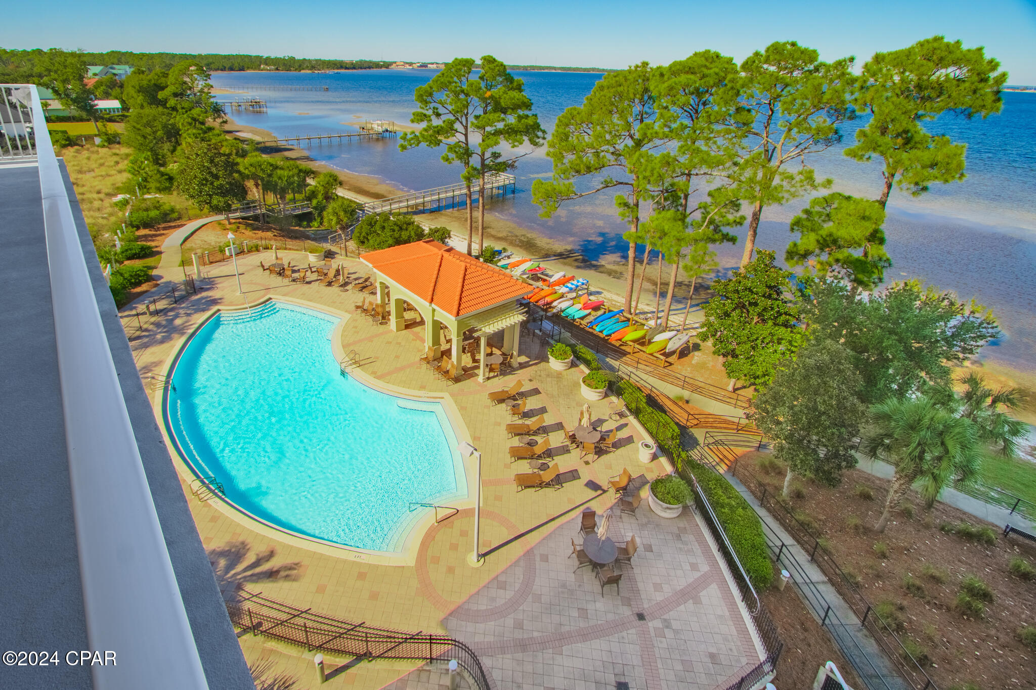 BAYFRONT LIVING AT MAGNOLIA BAY! Welcome to your coastal oasis at Magnolia Bay! This exceptional 3-bedroom, 3-bathroom condominium  nestled on the serene bayfront, offers a lifestyle of luxury and convenience. Featured are  two master bedrooms and private bathrooms, with an added bonus of a generously sized bonus room, perfect for a second bedroom or your home office. This condo features stainless steel VIKING appliances, custom granite countertops, tile and luxury vinyl plank flooring throughout, a custom marble wall under the kitchen bar area, plantation blinds and custom drapes, new hot water heater 2017, and new HVAC and dishwasher. The open concept design seamlessly leads to an expansive, wrap around, corner balcony, inviting you to enjoy bayfront views, including those mesmerizing sunsets! This bayfront condo is a coastal living haven, just a short boat ride away from the emerald waters of the Gulf of Mexico.  This gated community boasts a wealth of amenities for your pleasure to include a waterfront fitness room, a community room complete with a pool table and a pool that is heated during several months. For outdoor enthusiasts, a pier and kayak rack are available, ensuring you can make the most of the bay at your leisure. This unit comes with one covered parking space.  Don't miss the chance to experience bayfront living in this splendid coastal condominium! As always, dimensions are approximate. Buyer to verify if deemed important.