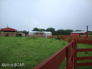 3 Bedroom 2 Bath Doublewide Mobile Home on 10+ Acres. Fenced and Cross fenced pasture. Decorative Board fencing across the front and entrance. 36 X 32 Horse Barn with stalls. 2 additional Barns. Frontage on paved county road. Short distance to town. Additional land available.