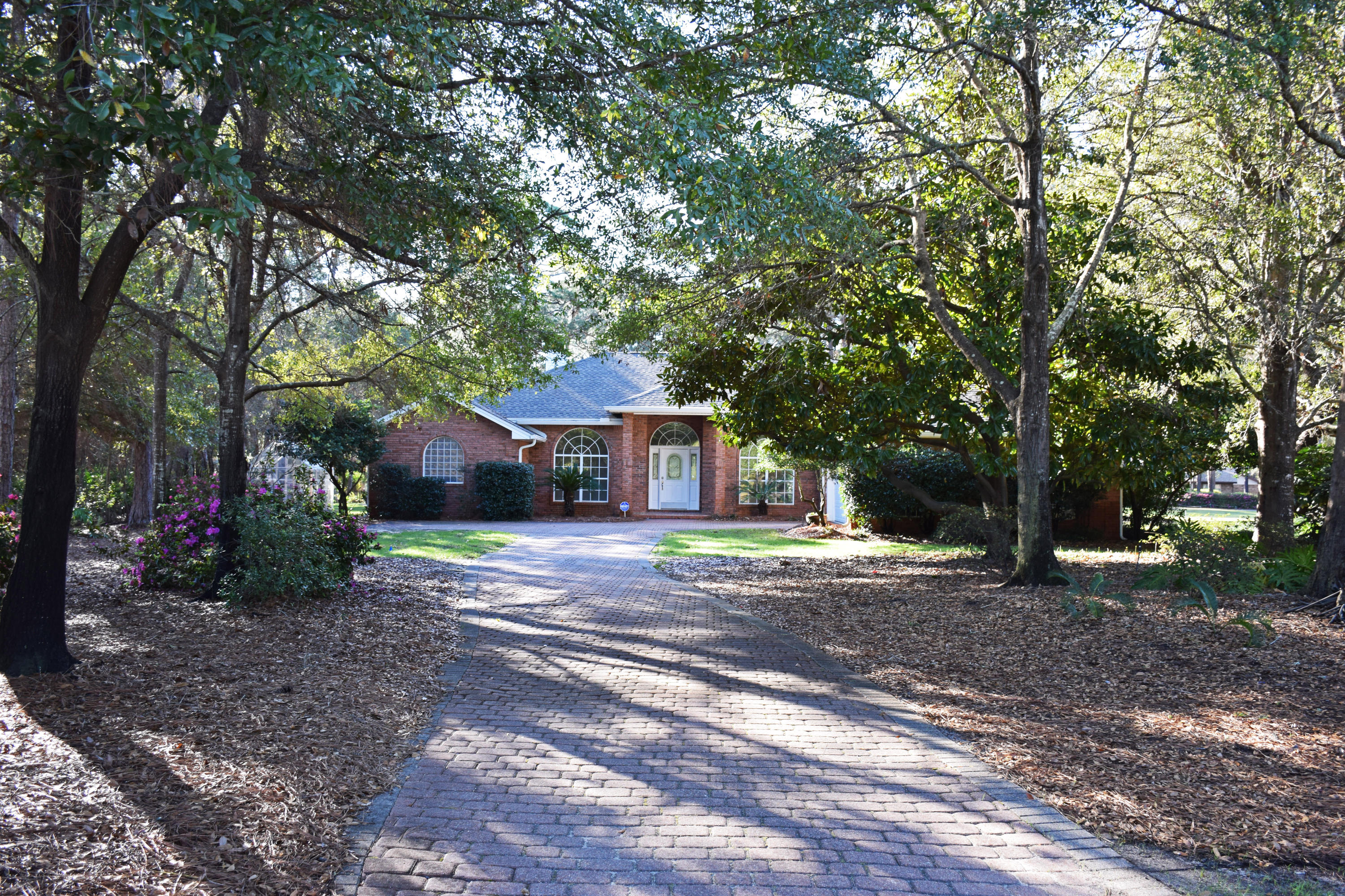 Sparkling with personality! This one-owner brick contemporary is ready for YOUR family! Sited about 70 feet back from the road and accessed by a tree-lined driveway, it feels as if you are entering a mini-estate. The back of the entire home is glass so you will enjoy not only views of your lush backyard, but also the 5th fairway of the golf course.
To enhance an open, airy feeling, the front of the house was designed with graceful arched windows. The great room features a 10' ceiling. The study and dining rooms offer additional 1' trays again creating a feeling of openness. You'll love the updated eat-in kitchen with its brand new granite countertops and bright white cabinetry. The high bar serves as a casual eating area and blocks your guests' view of your food prep space! The stainless appliances, including the LG convection range with double ovens, date from 2011.  A pretty Tiffany-style lamp accents in the dining area. 
The highlight of this delightful home is the 1062 SF Florida room with its cathedral ceiling and floor- to-ceiling, Xenon-filled, low-E,140 mph-resistant  windows.  The panels on the walls are 6" thick. Tiled with slate-look porcelain tile and heated and cooled by 2 commercial-grade mini-split heatpumps, this sun-bright space brings the outside in.  You'll love the way the indoor light changes as the day progresses.  Even rainy days can be special from this wonderful room.  The owners set aside a corner for their pet birds--a floor- to- ceiling screened area with a water hose and and drain-- accented with colorful parrot paintings. Even if you don't have pet birds, this enclosure would work well for other kinds of pets or even as an indoor gardening area.  
The master suite offers not only a sleeping area but also a bonus space with multiple uses (office, nursery, exercise room).  There are his and hers walk-in closets leading into the cathedral-ceilinged bath where there is ample space for two people to get ready for work or for a night on the town.

The additional two bedrooms and bath are on the opposite side of the house, away from the busy living areas and close to the laundry-- a pretty sensible arrangement.  Both are oversized compared to standard kids' bedrooms so they could be shared.  
The oversized garage easily holds two vehicles and a golf cart.  There is room for other things like bikes & lawn equipment. There are also pulleys for hanging your kayaks.  The attic space is floored; there are wooden panels for storm protection for the front window. Also a handy sink.

Practical facts:
1.  10-zone sprinkler system with a lawn pump
2.  Citrus trees, blueberry bushes, blackberries, raspberries, muscadine grapes and more all grow in the backyard so you'll really enjoy the greenhouse.
3.   Amana gas/electric heat and air system complete with a UV filter was installed in 2013.
4.  All duct work cleaned in 2014 and ducts re-sealed.
5.  Hot water heater- 2014
6.  Interior painted in 12/16.
7.  Carpets date from 2013.  Freshly cleaned.
8  Dimensional roof installed in 11/2016 

EXCEPTIONAL is the best word to sum up this feature-filled, family-friendly HOME!!  See it today!