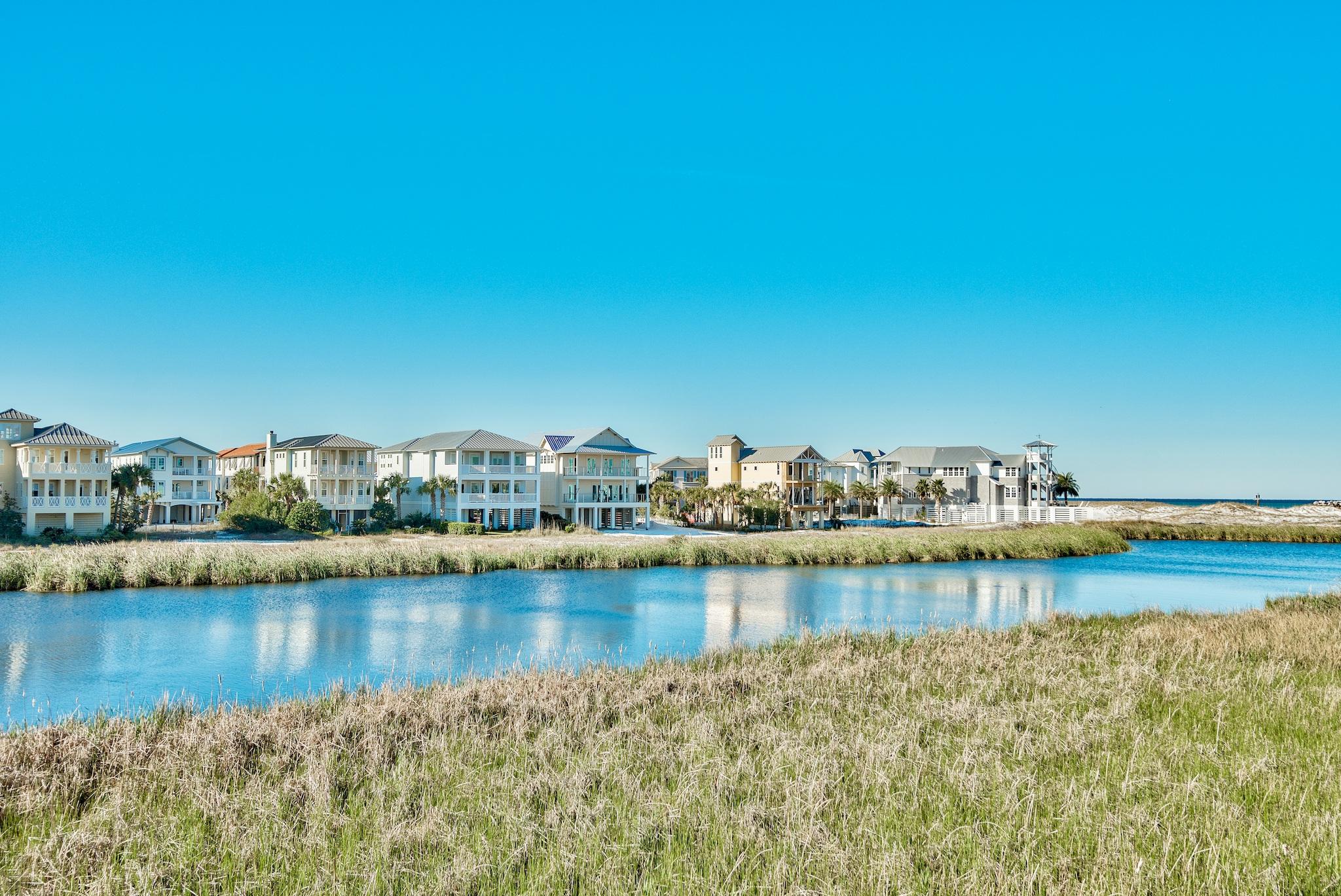 Exceptional vistas and attention to detail define this newly constructed coastal retreat. This contemporary lakefront home affords its owner with extrordinary views of lake Christina, Destin's East Pass and the Gulf of Mexico. It's well appointed and has been meticulously thought out from design to conception with its two gulf side master suites, two guest suites and additional bunkrooom with four berths which make this home an ideal retreat for large families. In total there are five and a half baths; giving each bedroom including the bunks, their own bath. Interior finishes are impressive with notable features such as tongue & groove ship lap siding, vaulted beamed ceilings, private elevator; along with wood and tile floors throughout. The first floor features an open living concept.... ......open living concept with kitchen, dining and living all open to one another and each enjoying the lake, pass and gulf views. The kitchen offers custom cabinetry, quartz  countertops, stainless steel appliances including a double oven as well as an oversized pantry with ample storage. Adjoining the kitchen is the generously-scaled dining and living areas which flow out onto the expansive rear deck that spans the entire width of the home allowing for easy indoor/outdoor living. Also on the first floor is a private guest suite with its own bath and private balcony. Journey upstairs and you will discover two finely appointed gulf side master suites; each with vaulted ceilings, private baths and tremendous water views. Both suites afford their inhabitants relaxation, seclusion and covered balcony perfectly framed by gulf & lake views. The east master features a spa-like ensuite bathroom complete with a large soaking tub, dual vanities and a walk-in shower, while the west master features an ensuite bathroom with oversized walk-in shower and dual vanities. The second floor also includes an additional bedroom suite with private bath, plus a custom-built bunk room with its own private bath. This home was thoughtfully appointed with laundry rooms and large closets on both the first and second floors; along with outdoor shower and ample covered parking and outdoor storage. Destin Pointe is a private, gated island community located in the heart of Destin's harbor district. It features 24 hour security, 3,000' of deeded beach access, two lakes, shuttle service to and from the beach, two pools, two tennis courts, access to the East Pass with snorkeling and fishing as well as close proximity to the world class restaurants, boating, shopping and entertainment Destin has to offer!