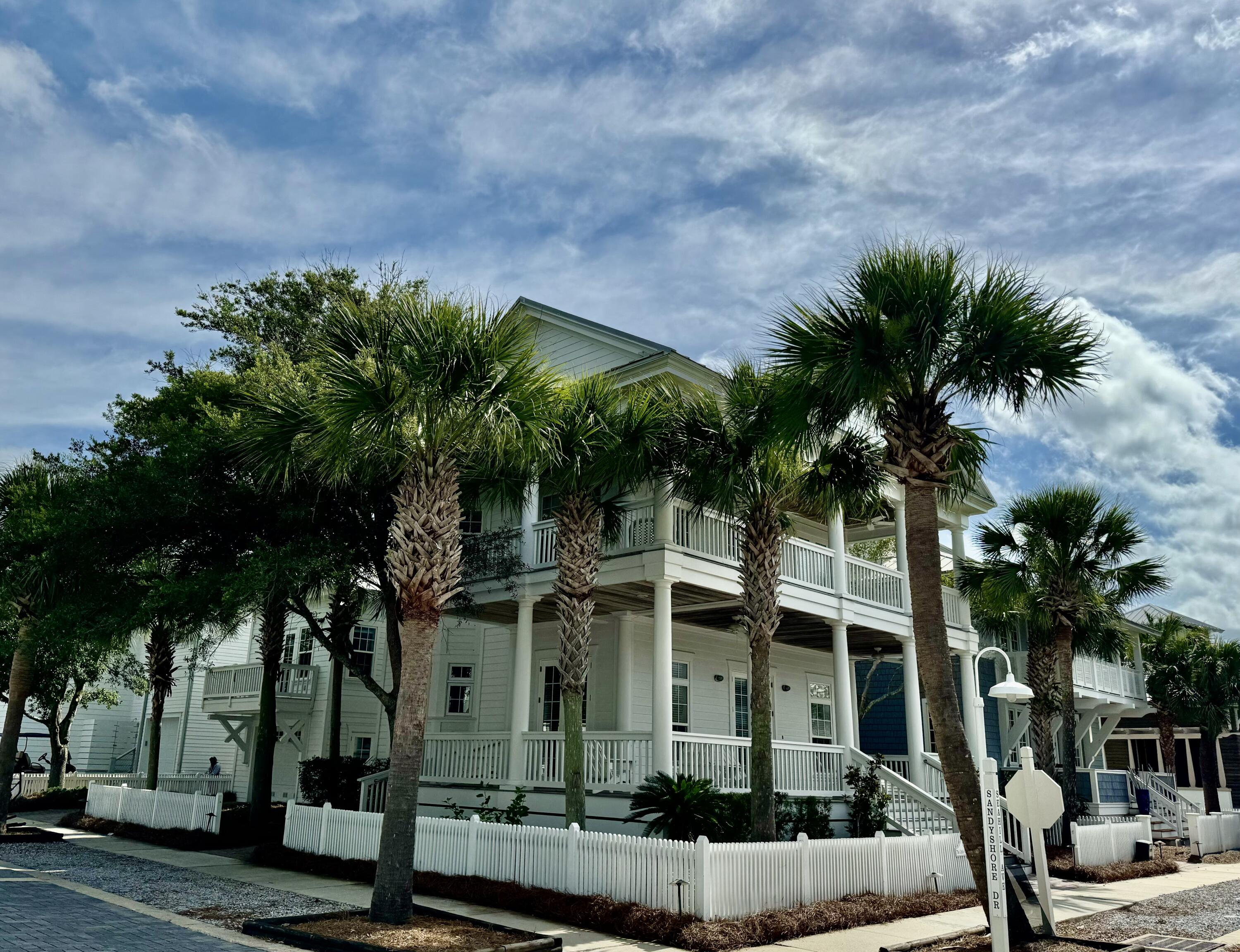 This is a lovely southern style coastal home with abundant wraparound porches for outdoor living and enjoyment. The corner lot and mature oak trees add to the beauty.  The main house has 2 bedrooms and 3 full baths with large great room/kitchen/dining open space - an entertaining dream. There is also a Carriage House with studio apartment and one car garage. This would be a great property for a second home, an investment property, or full time residence.  Enjoy the privacy of Carillon Beach's gated beachfront community with 3 pools, tennis, pickle ball, and basketball courts, green spaces for activities and 4,000 linear feet of beach.  The property is located less than a block from beach walkover #1 and the Bellview Pool and playground.   This great property is priced to sell.