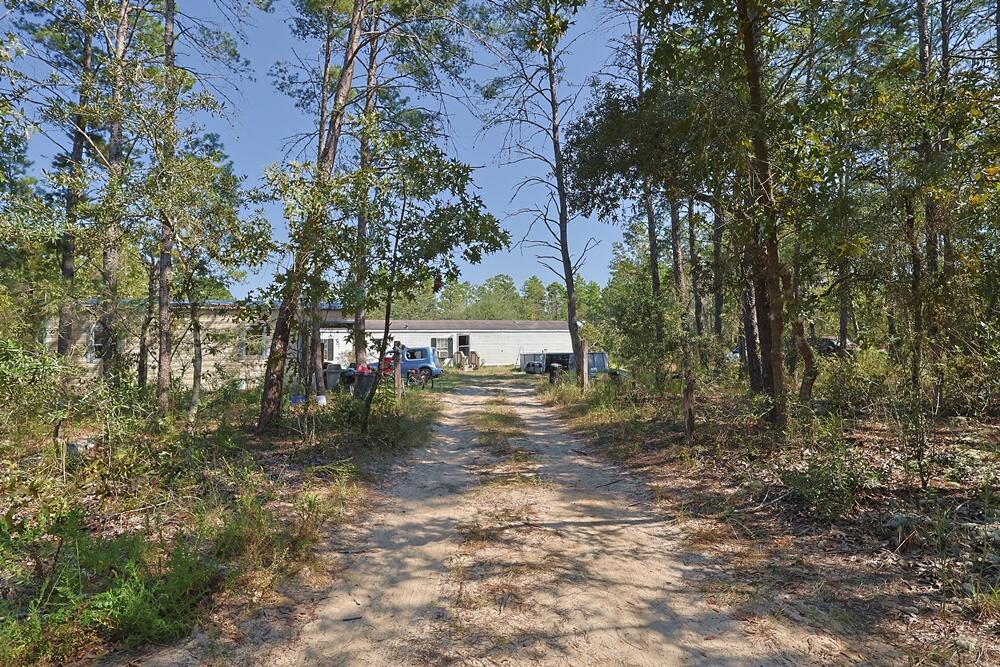 Freeport 5-acre parcel with 3BR/2BA mobile home (2000). Wooded setting near a creek on a quiet dead-end country road with multiple access points from J W Hollingston Rd. Home is occupied and sold in need of a full rehab; roof and appliances appear original (2000). Value may be in land and potential—bring your contractor or builder. Ample space for trails, gardens, or storage (verify uses with county). Showing by appointment only; please do not disturb occupants. Buyer to verify all measurements, access, utilities, flood/soil, and all pertinent information.