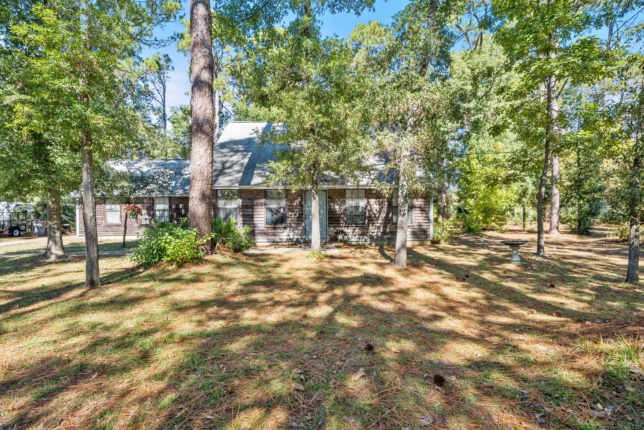 ** BACK ON MARKET- NO fault of the seller or property* Discover a rare opportunity to own over ONE acre in Panama City Beach! If you've been searching for privacy, space, and convenience, this property checks every box. Tucked away on a beautifully wooded lot with no HOA, you'll enjoy true peace and seclusion surrounded by mature trees while still being just minutes from the beach and away from heavy tourist traffic. The home offers a spacious and functional layout with an open living area on the main floor, complete with a cozy fireplace and great natural flow into the kitchen and dining spaces. The primary bedroom and full bathroom are conveniently located downstairs along with an additional bedroom. Upstairs you'll find two more generously sized bedrooms and a full bath, offering flexib property offers exceptional potential.