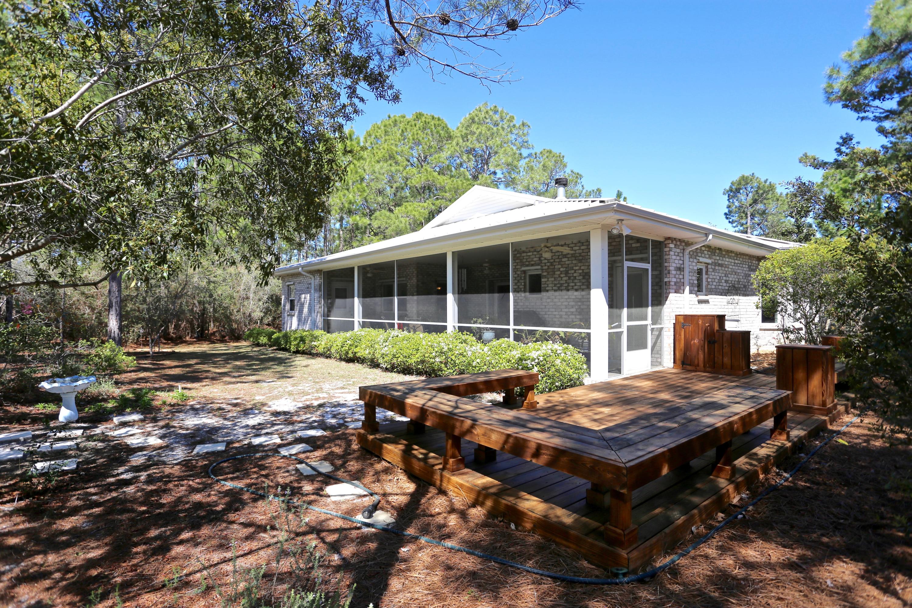 Santa Rosa Ridge is located on one of the highest dunes in South Walton, just off Scenic 30-A. Country living within walking distance of the Emerald waters of the Gulf of Mexico. Shopping, dining and art galleries are all within a few minutes drive. Almost a full acre located on a small, serene lake. Sit on your screened in porch and watch the wildlife. Quality workmanship of steel frame, brick exterior, metal roof with a/c storage room in attic. New Carrier 3.5 ton HVAC. Wood decks on two sides, outdoor shower. Yard building for storing garden tools and beach toys. Hurricane shutters. Two car garage and covered front porch. Side deck for enjoying the evening breeze at sunset. Santa Rosa Golf Club is just across the road.