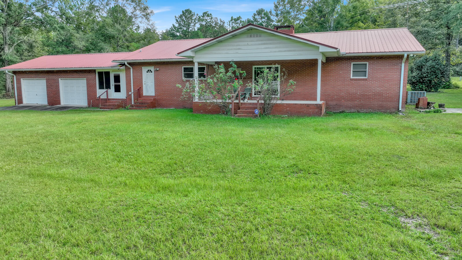 Price Improvement! !!   Spacious 3 bedroom, 2.5 bath, home on 15.73 acres fronting paved road in the country. Beautiful red brick home has a paved driveway. Roof is heavy duty red metal installed about 10 years ago. Formal living room has large fireplace with heat-o-lator. Floors are wood, tile, & carpet. Large kitchen with cabinets galore, has oversized window, recessed lighting, island, KitchenAid convection microwave wall oven combo, trash compactor, dinette area & walk in pantry. Formal dining room. Extra large utility room with renovated half bath. Breezeway to oversized 2 car garage with work benches. Whole house generator serviced regularly. MBR has walk-in closet. Anderson windows & sliding glass door installed 10 years ago. Covered front & back porch. 3 storage sheds,garden area