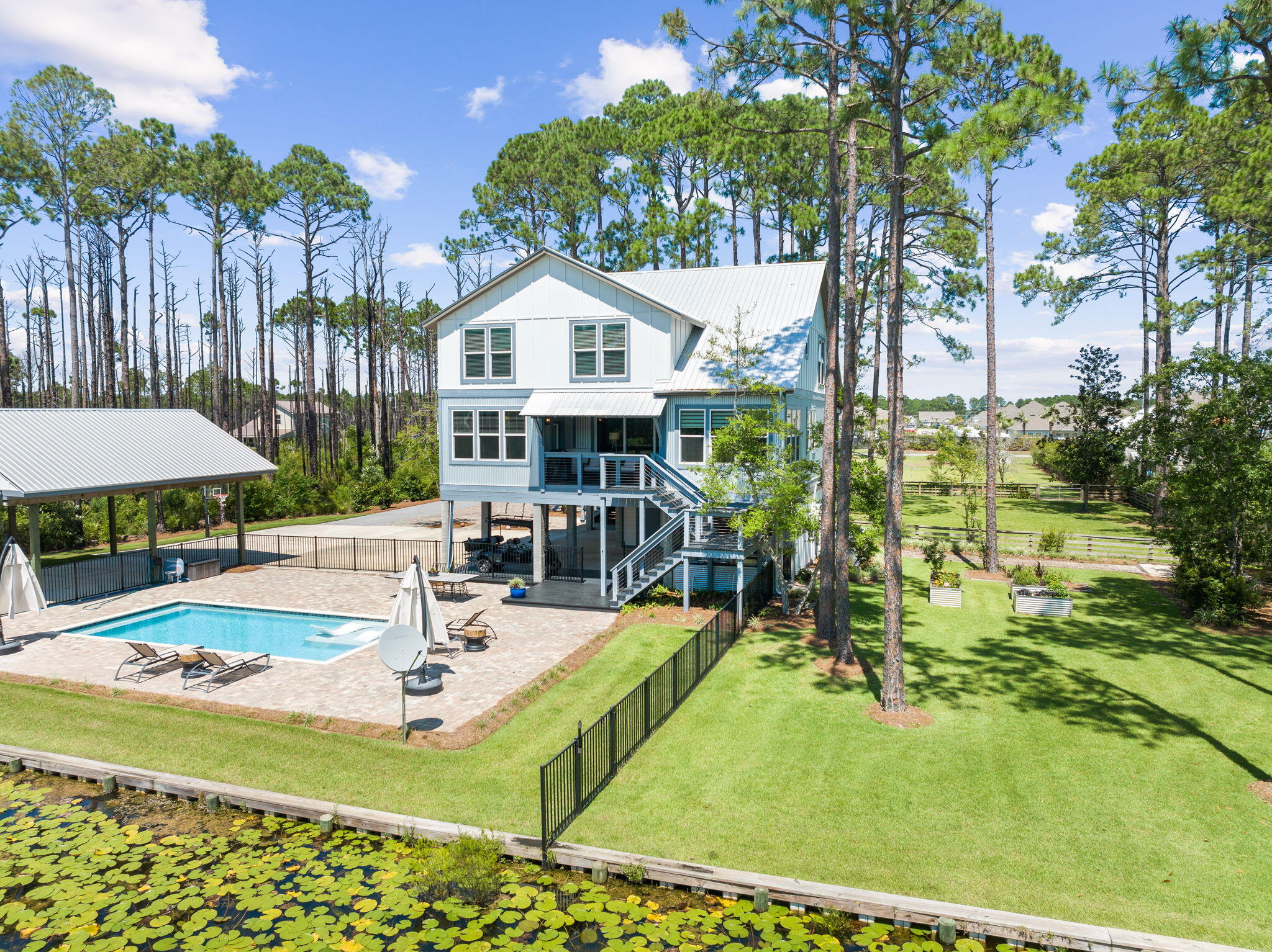 Secluded South of Hwy 98 this gated 4+ acre Dune Allen family compound has it all and with a quick golf cart ride you will be at the beach in less than 4 minutes. The 2 story custom built home & carriage house over 1 car garage, 30 x 24 wood pavilion for RV parking, with water and electricity hookup, saltwater swimming pool all facing the natural fishing pond with firepit & dock! The home with 3,100 sq ft, 4 bedrooms, 3 full baths, Power Room off the foyer along with the carriage house with bedroom, sitting area and full bath truly provide a haven for all - even the yard is fenced in for your pets. Downstairs of the main house is a conditioned storage area with a workbench along with additional storage closet in carport, outdoor grilling station with sink, refrigerator and DCS Grill, two side burners and bar sitting area give way to the entrance to the backyard oasis. Southern Blue Pool company built a beautiful saltwater pool, splash ledge and fountain with paver decking and iron railing fence. Inside the home several of the highlights are wood plank tile, barn door enclosure for television, porch access from dining room and primary bedroom, 2nd floor living space, wood plank ceiling accent and the well appointed kitchen with Quartz counters, Bosch dishwasher, GE gas range with griddle, double convection oven, painted cabinets, bifold pantry and views of the 4+ acres. All the shopping, restaurants and the joys of the 30A beaches, bike paths and the emerald waters of the Gulf provide many opportunities to live your best life. 

Appraiser measured SQ FT House = 3439 + Studio = 480 for a total of 3919 heated and cooled living space not including the carport conditioned storage.