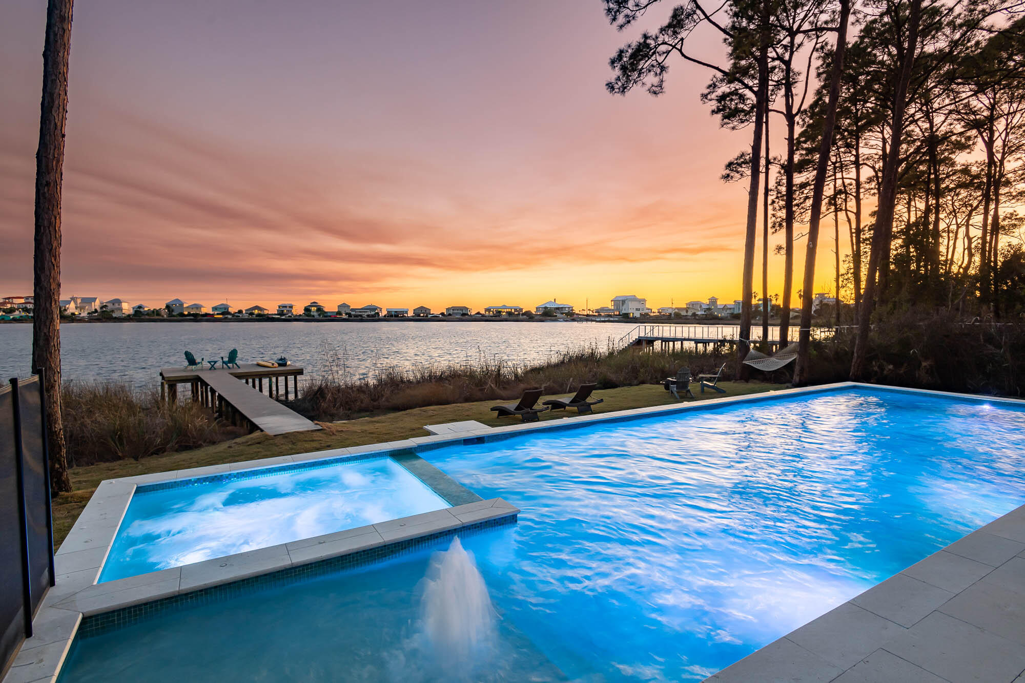 LOWEST PRICE PER FOOT HOME FRONTING A COASTAL DUNE LAKE ON 30A! Newly renovated in 2024 - The epitome of coastal dune lake living awaits in this custom lake-front home. The Seller has made immense upgrades including: new flooring throughout the entire house on all three floors, an additional first-floor bedroom with brand new en-suite bathroom, brand new kitchen countertops & plumbing fixtures, a new first floor wet bar, a freshly painted house & carriage house, a new roof, new estate sized 20' x 45' heated pool with a hot tub, summer kitchen, new dock, completely renovated 3rd floor including outdoor tiles, new wet bar, new flooring, and renovated bathroom. 119 Oyster Lake Drive boasts 8 bedrooms and 6 full bathrooms, with classic shingle siding and a timeless, Northeast coast flair. Situated on a bluff with its elevation above neighboring homes, this lake-house boasts just under 5,000 square feet. Step outside and take in breathtaking views of Oyster Lake, a rare coastal dune lake where you can spend the afternoon fishing or paddle boarding directly to the beach! Multiple public beach accesses are less than ¼ mile away. One of two ingress/egresses to the property features a well-maintained bridge over conservation land and provides a serene entryway and unrivaled privacy.

The main home is three stories, with breathtaking unobstructed lake and gulf views from each floor. The first floor features an elegant and spacious great room, with multiple living areas and a first floor bedroom with king sized bed. The kitchen is open and airy - a chef's dream - with a large center island, an oversized 6-burner gas range with double oven, and large windows to take in the lake views. Step outside to the newly-constructed summer kitchen, complete with a gas grill, wine cooler, and additional living and dining space.

The second floor features the master bedroom suite, which includes a king-size bed and sitting area, covered balcony with swing overlooking the lake, ensuite bathroom with double vanity, shower with multiple shower heads, and a separate soaking tub. A second bedroom has a king-size bed and an attached bathroom with a tub/shower combo, while the third and fourth bedrooms each have king-size beds and share a Jack-and-Jill bathroom, with walk-in shower.

The third floor, perfect for the kids, includes two full-size beds and two bunk beds - one a full-over-full-size and one a twin-over-full-size. The third floor is completed with a full bathroom, game room, and balcony with birds-eye views of the gulf & lake.

Detached from the main home is the three-car garage and carriage house. This comfortable flat allows large families to have some extra space and privacy and features 2 bedrooms, one bathroom, living & dining areas, and a kitchen with full-size refrigerator, stove, oven, and microwave.