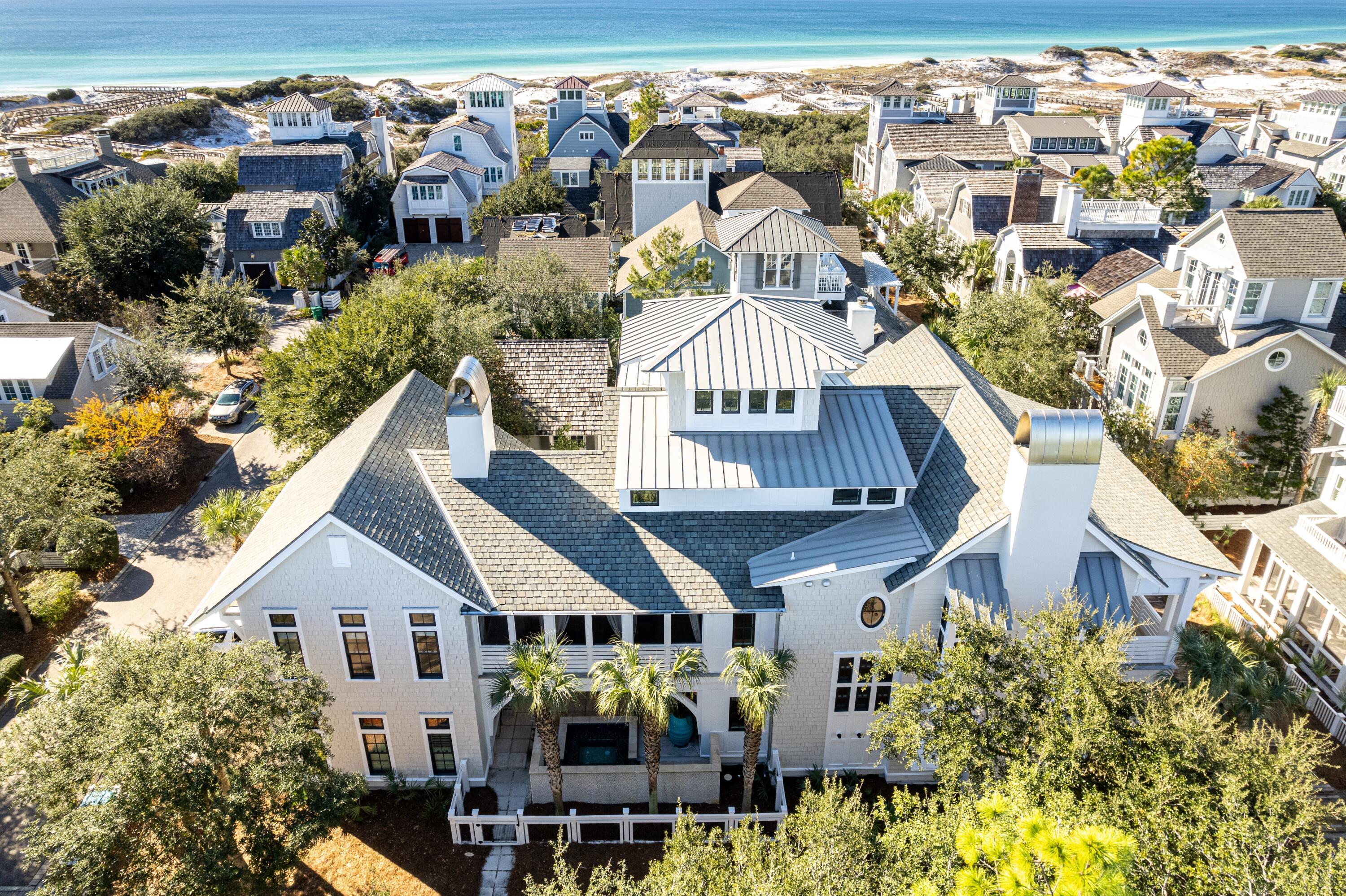 Designed by renowned architect Geoff Chick, this spectacular beachside retreat is located behind the gates of the exclusive WaterSound Beach community. This custom home is immaculate, no surface was left untouched. The impressive great room sets the tone for this sophisticated beach home. The soaring vaulted ceilings and custom beams add to the great sensation when entering. The oversized kitchen island is perfect for preparing meals and hosting friends, and the Soho Studio tile backsplash adds the perfect pop of color to this entertainer's dream of a space. The living space is accented by custom-ordered furnishings courtesy of Restoration Hardware, Bungalow 5 and Modern History. The custom drapes, pillows and cushions are all creations by Thibaut designs. The lights, sounds and temperature in this impressive room (as with the rest of the home) are all controlled via your phone or the installed iPad operating the Control4 system. The oversized pantry and washroom are just off the great room, along with a half bathroom designed to add flair to the home. The primary suite on the main living level is an inviting retreat with private access to the screened outdoor living area. The bathroom boasts a soaking tub and multi-jet shower with rain head above. Thibaut wallpaper adds a custom touch to this room, and the dual walk-in closets complete the suite. This level also showcases the climate-controlled wine cellar, complete with reclaimed wood racks that can hold more than enough wine for all guests. Just outside the wine room is the oversized screened porch. This entertaining outdoor area has a vast custom wood dining table, beverage drawers, a built-in Wolf grill and hood, and an oversized TV. On the other side of the porch is the fully independent carriage house. This suite has a kitchenette, a built-in dining area and a separate living area. Elevated ceilings and ample windows add a "wow" factor to these living quarters. The Kelly Hoppen canopy bed will tempt you never to leave this room. The first level boasts a grand entry hall with custom inlaid marble tiling and an overhead chandelier created by Arterriors. Dual guest suites on this level both have ensuite bathrooms. Both bedrooms are highlighted by John Robshaw bedding, Matouk and Thibuat pillows and drapes and art by renowned local photographer Modus Photography. Rugs by Dash & Albert cover the floors, and new quartz vanities and Waterworks plumbing round out these beautiful guest suites. Just down the hall is an additional bedroom doubling as an in-home office space with an attached full bathroom, equally appointed as the other guest suites. This level is completed by a bonus entertaining room that works for additional sleeping accommodations. Pull out the sleeper sofa and pull down the retractable viewing screen to create the perfect movie-watching spot. The linens, pillows, rug and artwork are all on par with what you would expect in a home of this caliber. Outside the theater room, you find the first-level outdoor living area featuring an outdoor fireplace, sitting area and spa. The large spa with spillover edge and waterfall feature impress upon approaching the home. Climb the stairs or take the elevator to the third level. You find a sitting area separated from the bunk room by a vast custom barn door. Built-in bunks provide additional sleeping for family and friends, and a full bathroom completes this level. There is one more set of stairs to climb to the enclosed watchtower. Here, you find lounge-level seating plus a bar top and stools looking through the windows and out at the Gulf of Mexico. When it is time to go to the beach, hop on your private golf cart (included in the sale) and drive right down the beach. The large "Dunesider" pool is just steps away (less than 150)