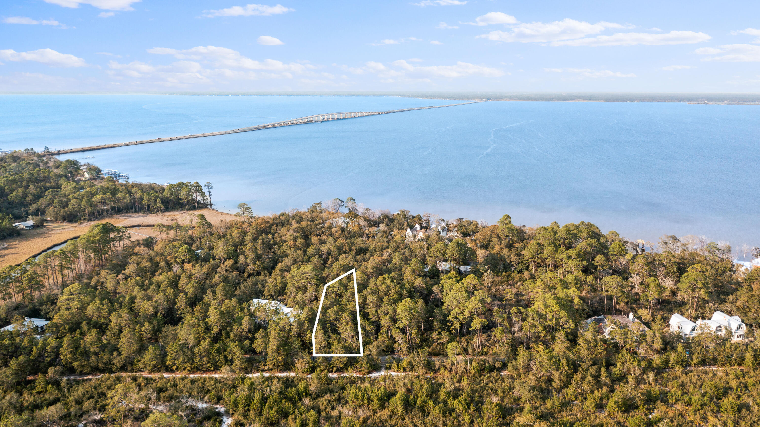 Perfectly positioned between 1,082 feet of Choctawachtchee Bay shoreline and the 15,000 acre Point Washington State Forest. Experience unparalleled privacy and naturalistic serenity from this exemplary legacy offering. Located in the gated enclave of the Estuary, one of the most exclusive locations along the Emerald Coast surrounded by State forest land. Relax with endless sunsets on the community dock, or head to the beach which is only 4 miles away! The best of both worlds is awaiting you.