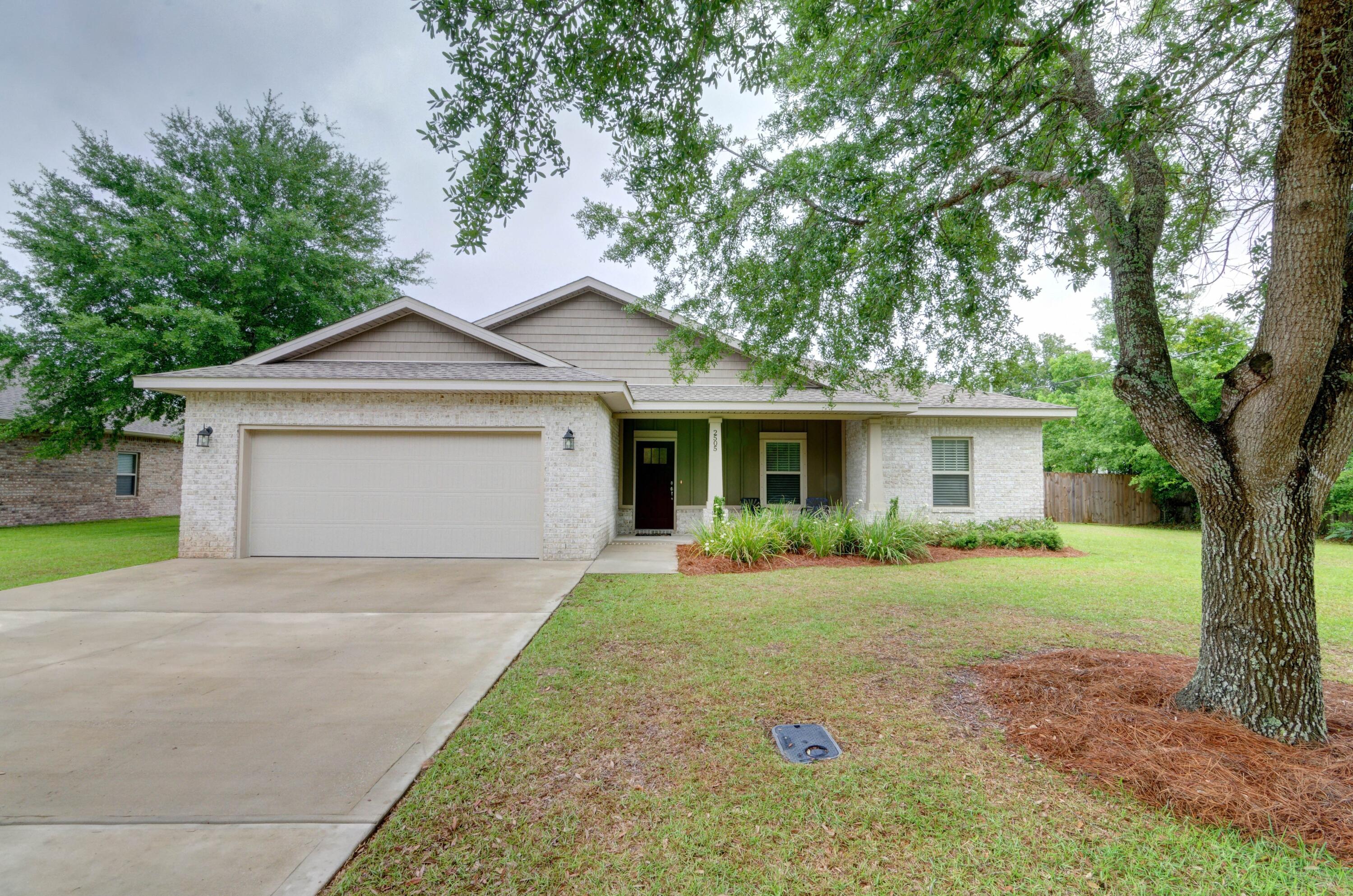 Practically new home located in a prime Navarre location with stunning upgrades throughout on a half acre lot (no HOA)! Clad with the timeless durability of brick, cement fiber board accents, and an architectural shingled roof, from the moment you pull up to the driveway and take in the tasteful landscaping and the spacious front porch you'll fall in love! Enter the front door and you'll find soaring ceilings with a trey ceiling and a fantastic long entry way. Custom paint color is accented with a wide baseboard, beautiful crown molding, and spectacular tray ceiling accents in the master bedroom, dining and entry area. Transom windows over the hall entryways provide a high end custom touch, along with the bedroom accent walls. The large living room is open to the stunning kitchen showcasing stainless steel appliances, stunning shaker style cabinets with soft close drawers, gorgeous backsplash, and granite throughout (including both bathrooms) finish the home exquisitely. Carpet is only found in the bedrooms and large tiled floors adorn each bathroom. The master bathroom is a retreat with double vanities, a separate soaking tub, a breathtaking walk in tiled shower with custom glass door and tiled bench, and your jaw will drop when you walk in the massive master closet. There is even a door from the master bedroom closet straight into the laundry room! The split floor plan features three bedrooms on the other side of the house with shared bathroom with the same features. Walk out the back door and immediately envision yourself enjoying the MASSIVE back covered patio! Enjoy a privacy fenced back yard (the property line extends well past the fence) and a full irrigation system on a well for the front and privacy fenced backyard. Welcome home!