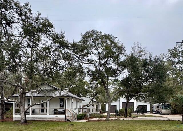 Excited to share this unique property conveniently located on Bay Grove Road, situated off Hwy 331 perfectly between 30A and Freeport. This property offers a rare combination of modern living spaces and versatile infrastructure with no HOA restrictions. The estate features a main residence and a detached carriage house, both built in 2022. The 1,834 sq ft main house includes 3 bedrooms and 2.5 bathrooms, while the carriage house provides a private living experience with 1 king bedroom, a full bath, a modern kitchen, a dining area, and a living space equipped with a fireplace and laundry area. Both homes are finished with durable LVP flooring, stainless steel appliances, quartz countertops and contemporary cabinetry. A significant highlight of this property is the 2,176 sq ft detached conditioned warehouse. Featuring three roll-up doors, on a concrete pad, and a metal roof, this space offers endless possibilities for personal use, RV storage, or workshop. The location provides easy access to local amenities and recreation, including Grayton Beach and Grady Brown Park just down the street  which offers a boat launch and sandy beach on Choctawhatchee Bay. It is also just minutes from the new Publix shopping center in Freeport and several popular local dining and retail establishments. With multiple dwellings and a substantial warehouse, this property presents a variety of opportunities for both personal enjoyment and income-producing potential.